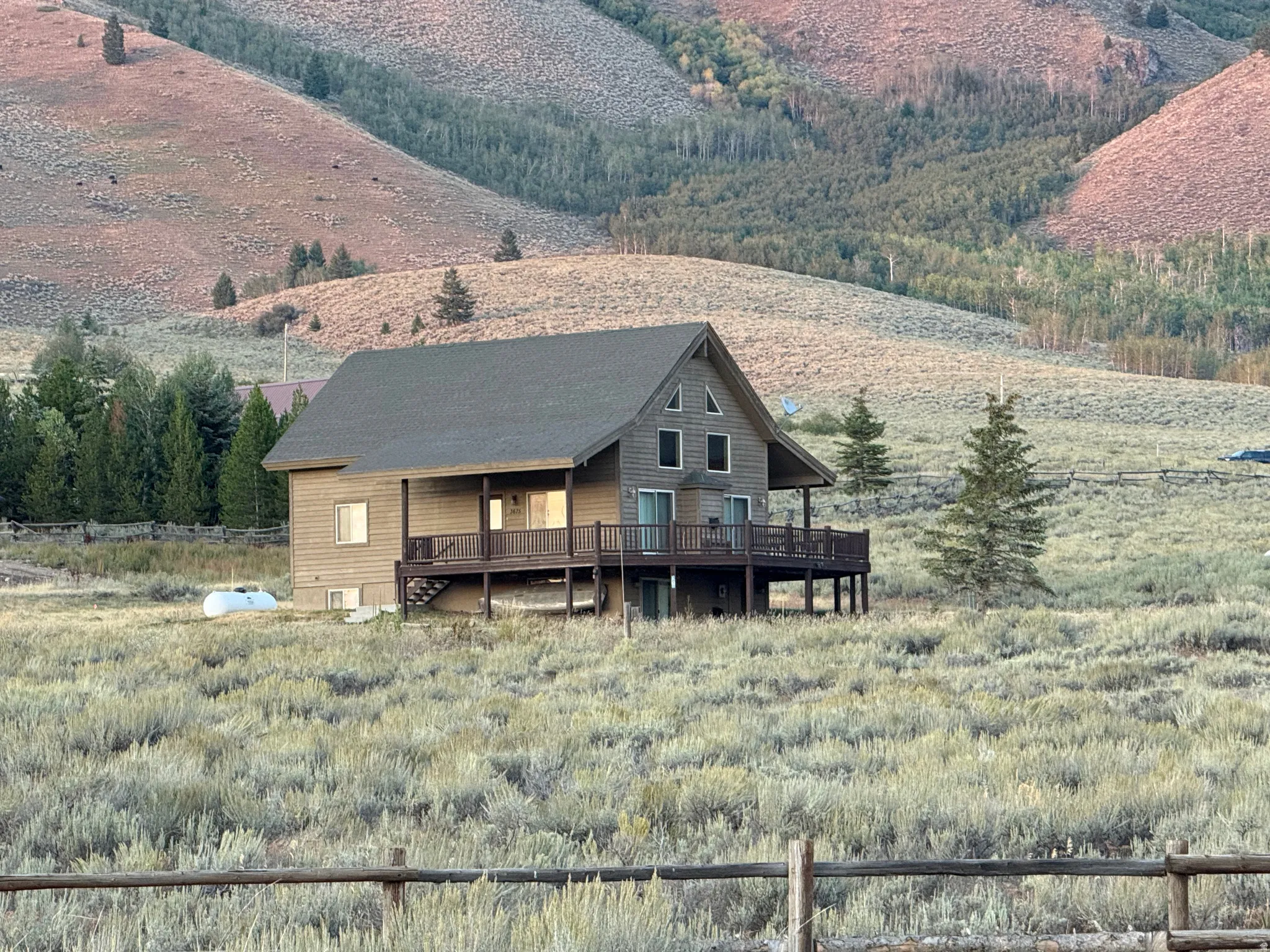 Rear view of property with a deck and a rural view