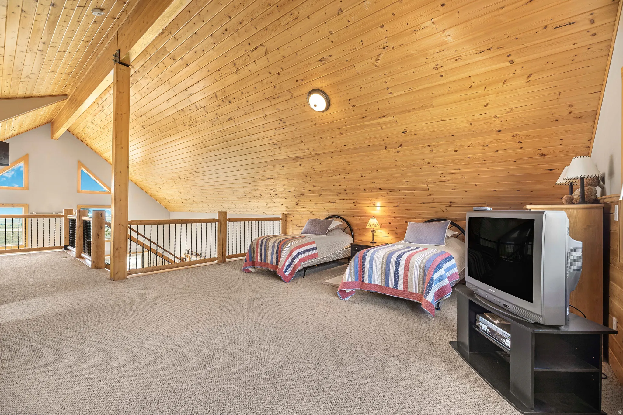 Bedroom featuring a wooden ceiling with exposed beams, carpet, wooden walls, and high vaulted ceiling