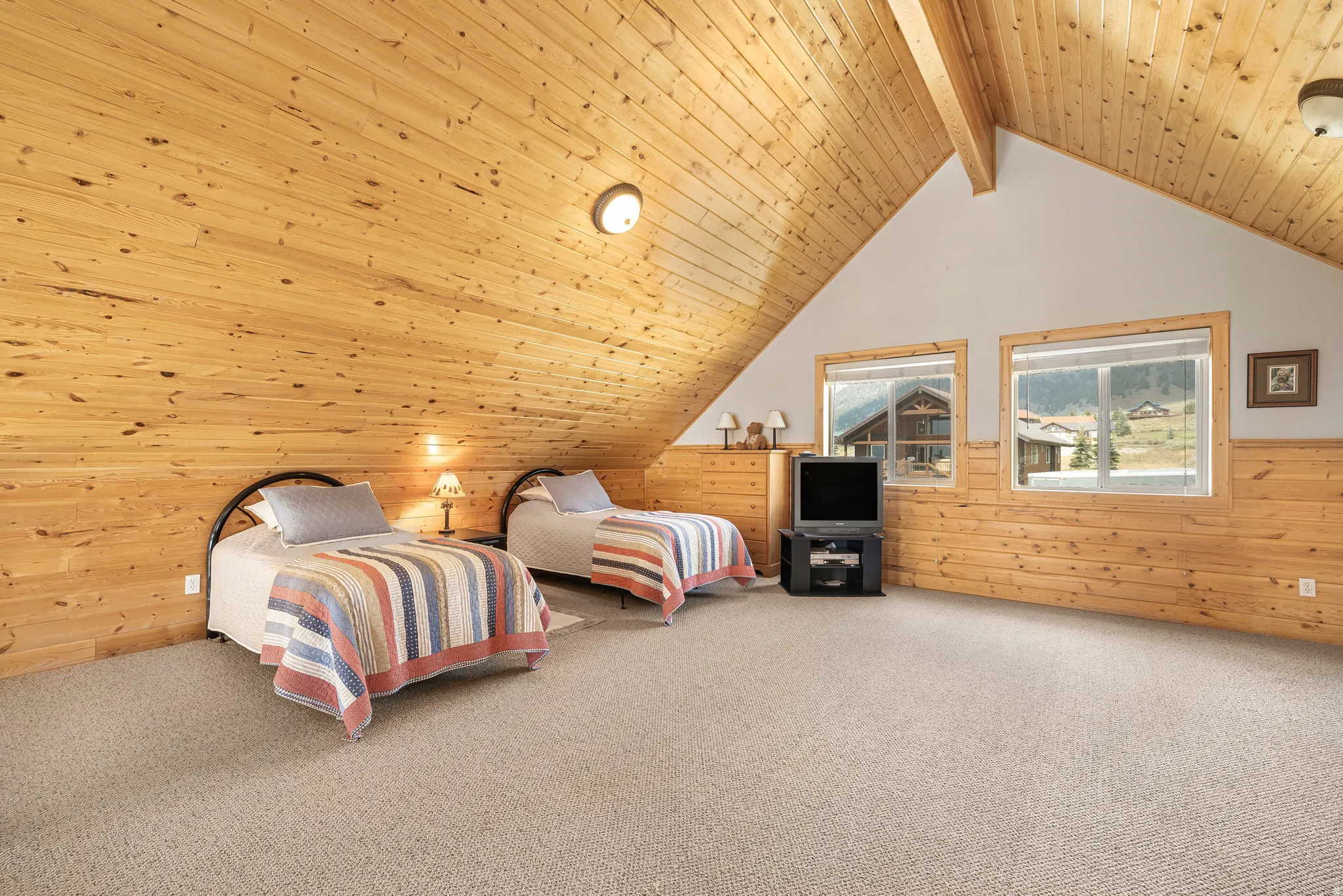 Carpeted bedroom with wood walls and wooden ceiling