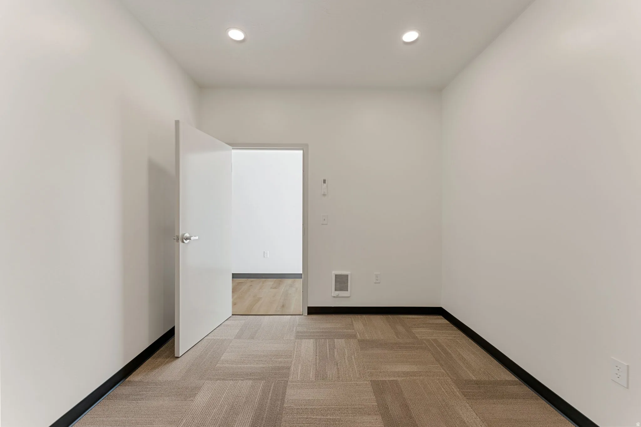 Unfurnished room with recessed lighting and light carpet
