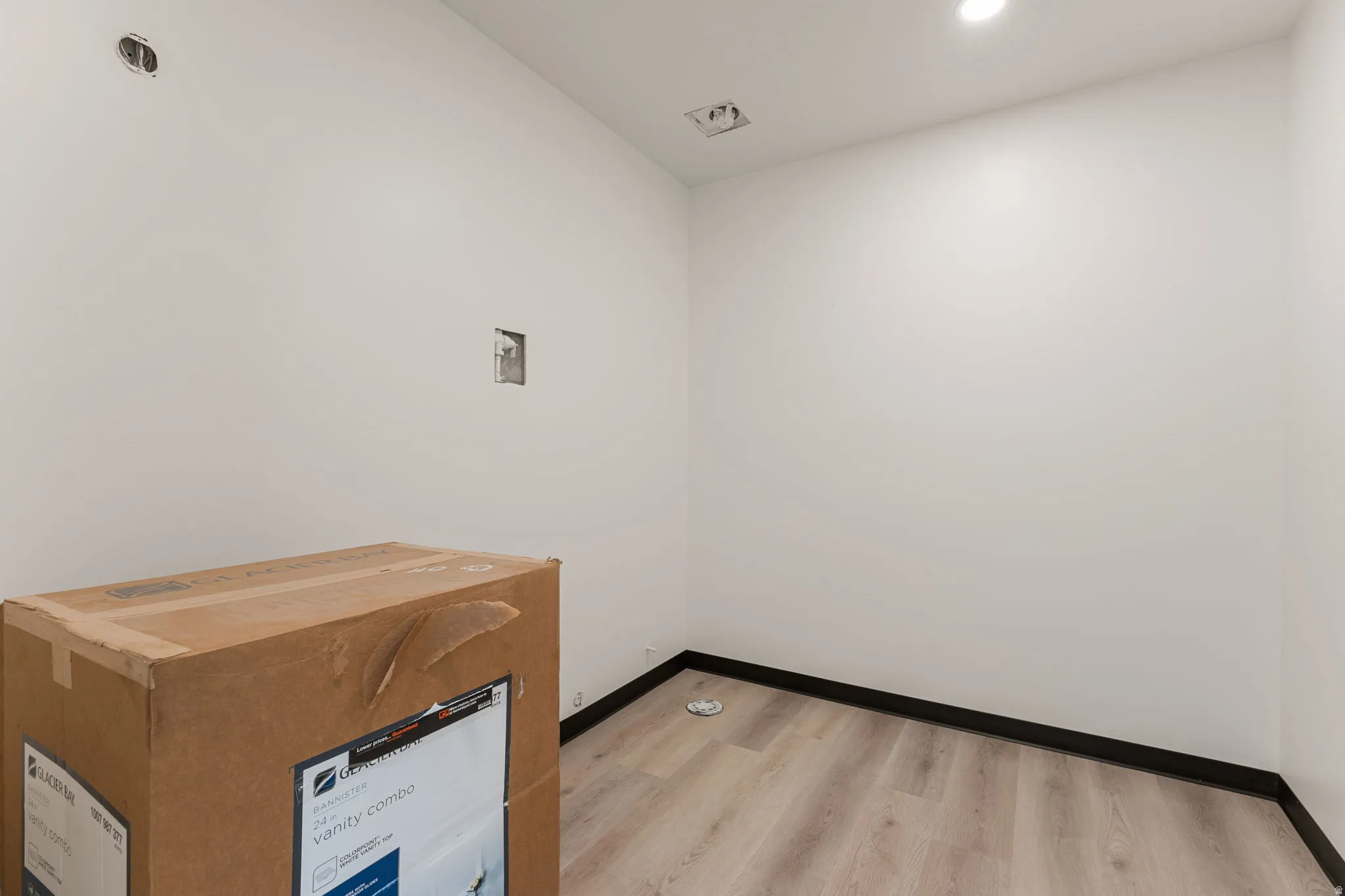 Washroom with light wood-type flooring and recessed lighting
