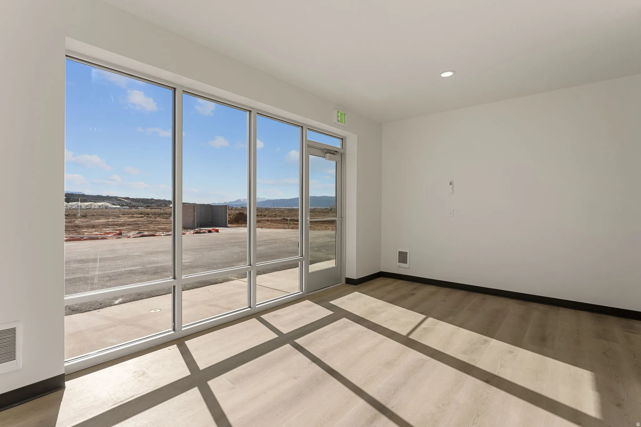 Empty room with light wood-style flooring, a mountain view, and recessed lighting