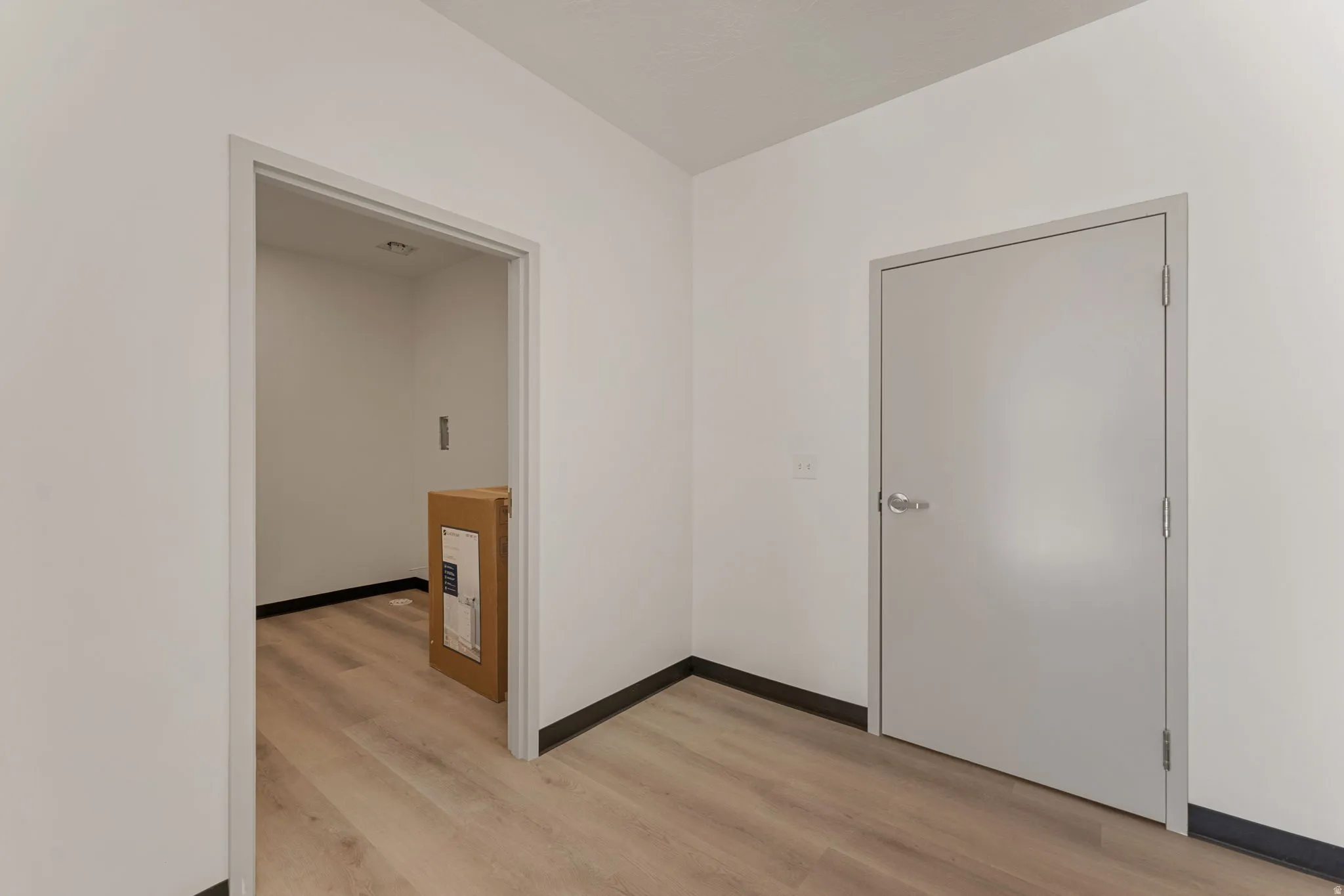 Empty room with light wood-style flooring and baseboards