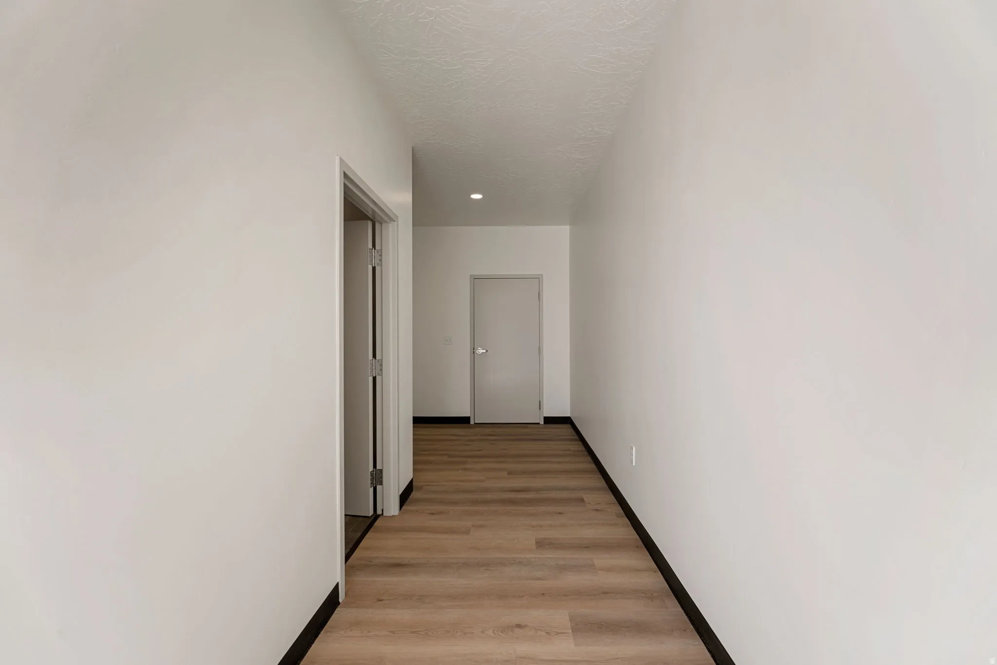 Hallway with baseboards and light wood-style flooring
