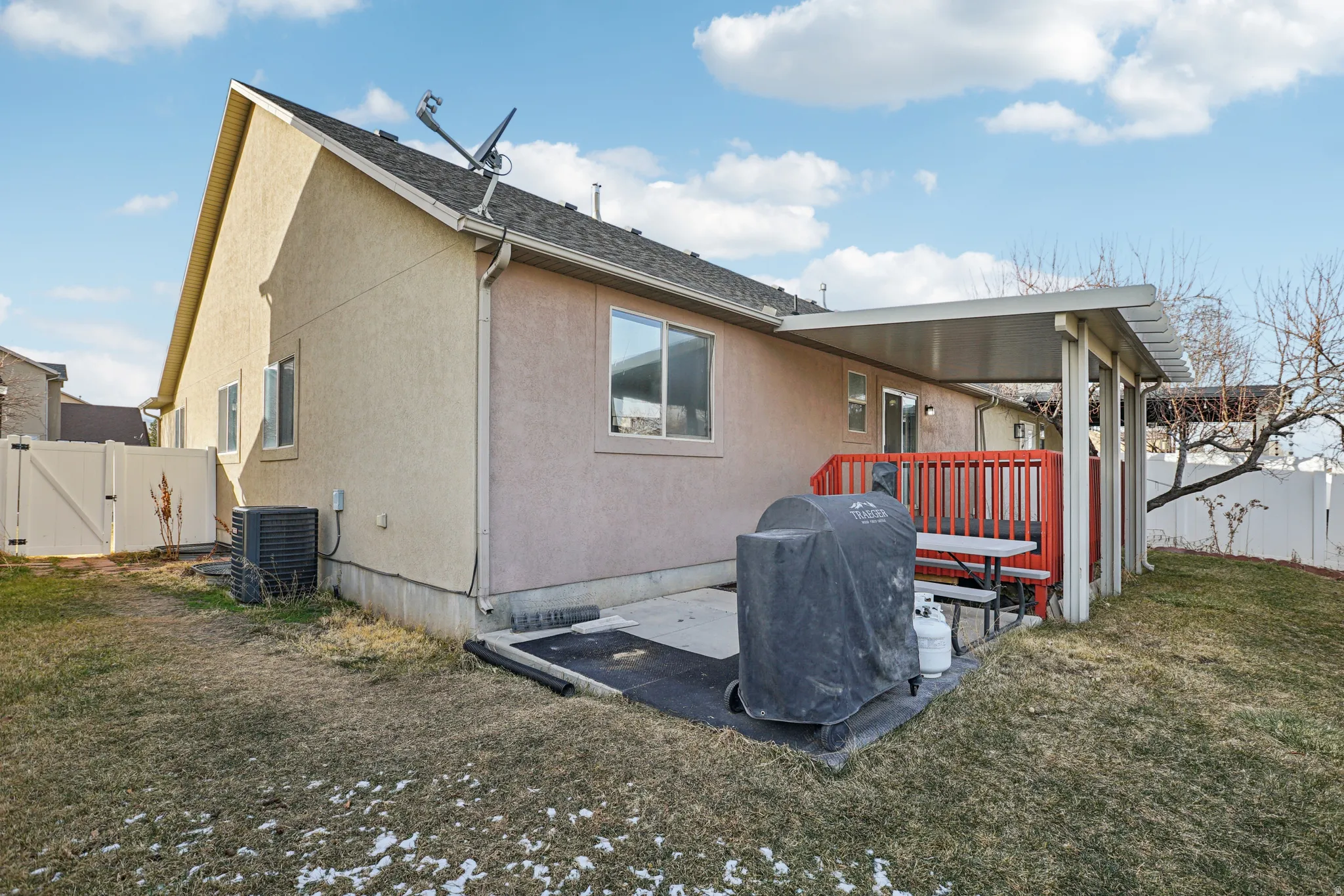 Back of property featuring a fenced backyard, stucco siding, a gate, and a patio