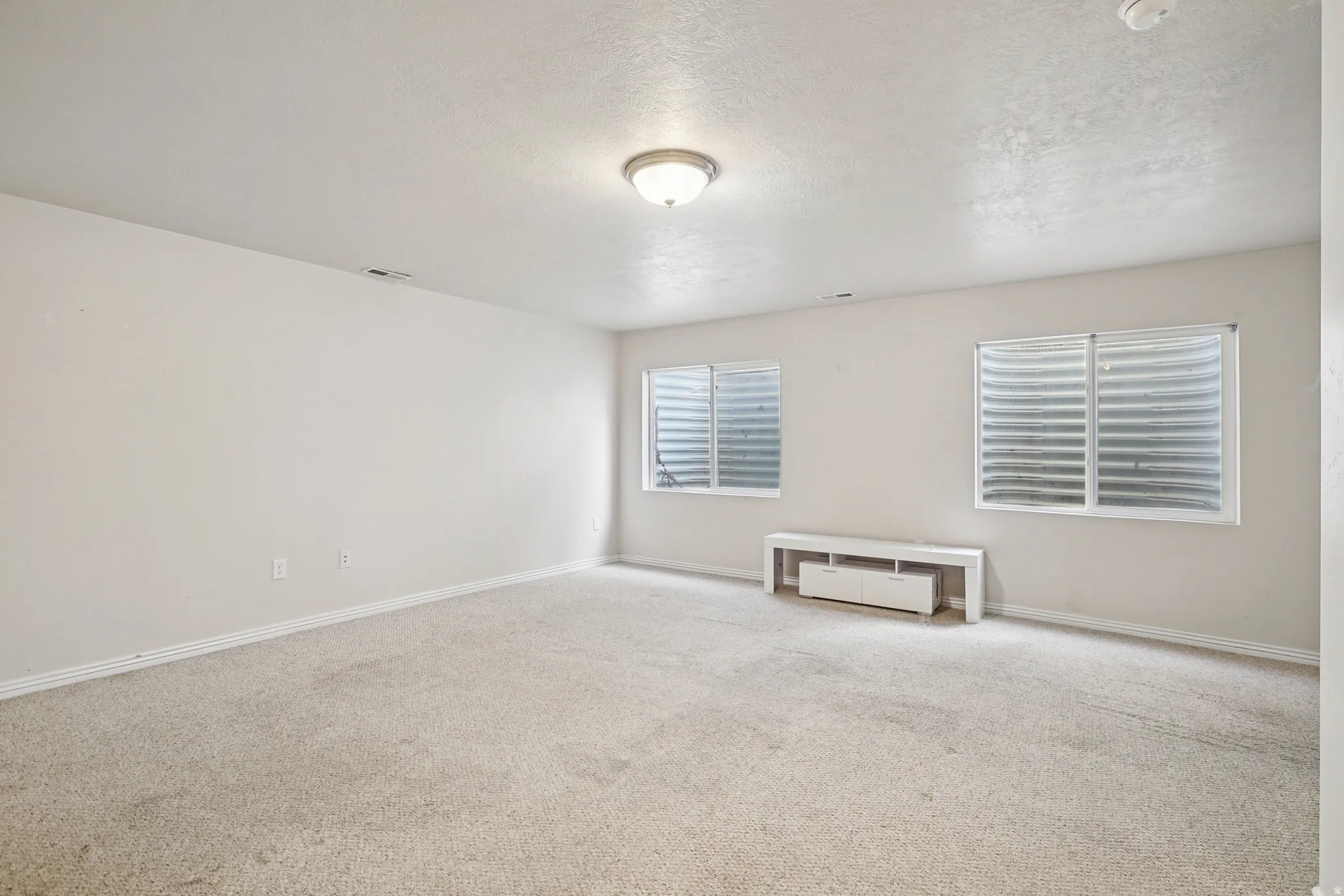 Unfurnished room featuring carpet floors and a textured ceiling