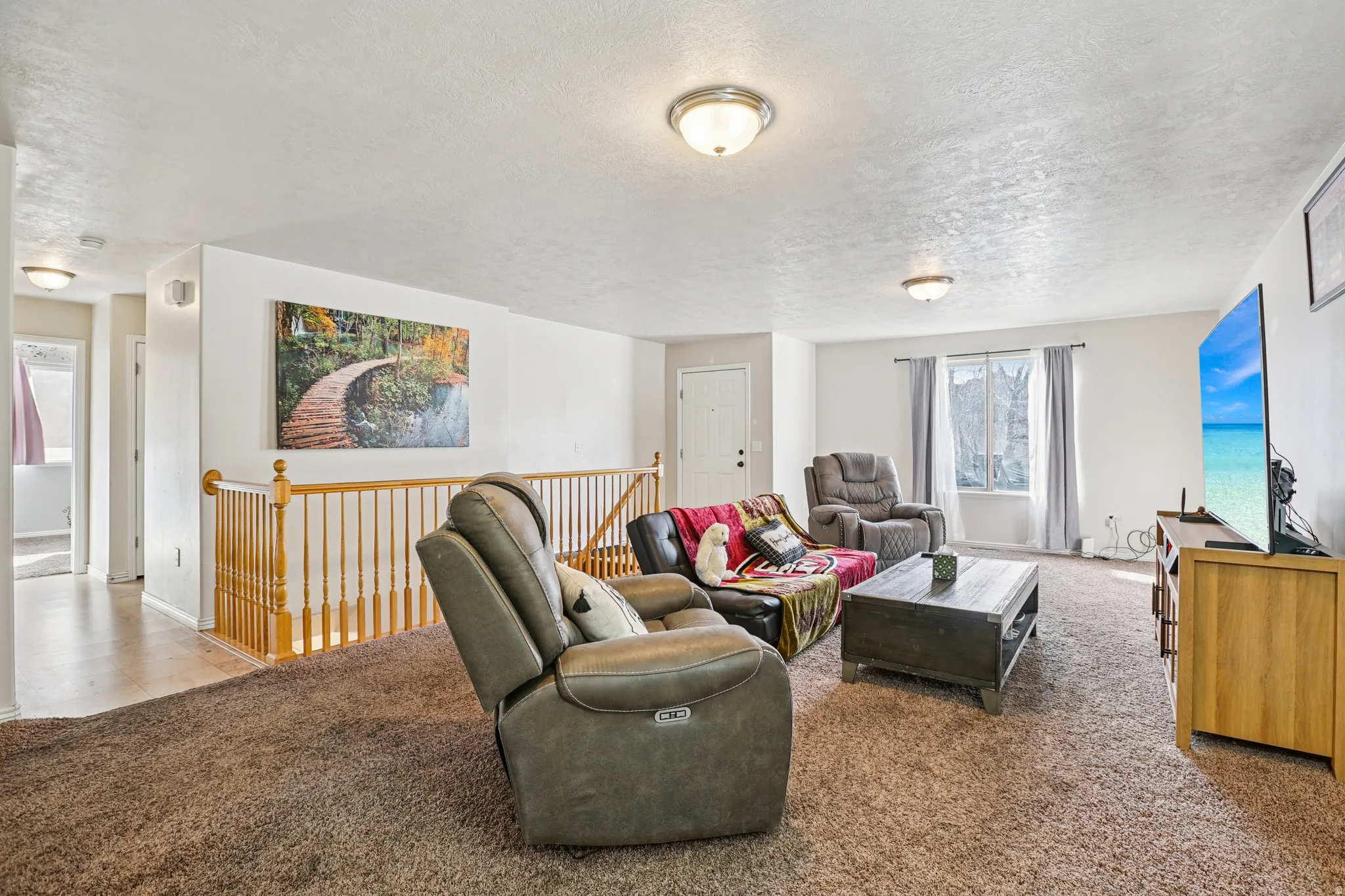 Carpeted living area with a textured ceiling
