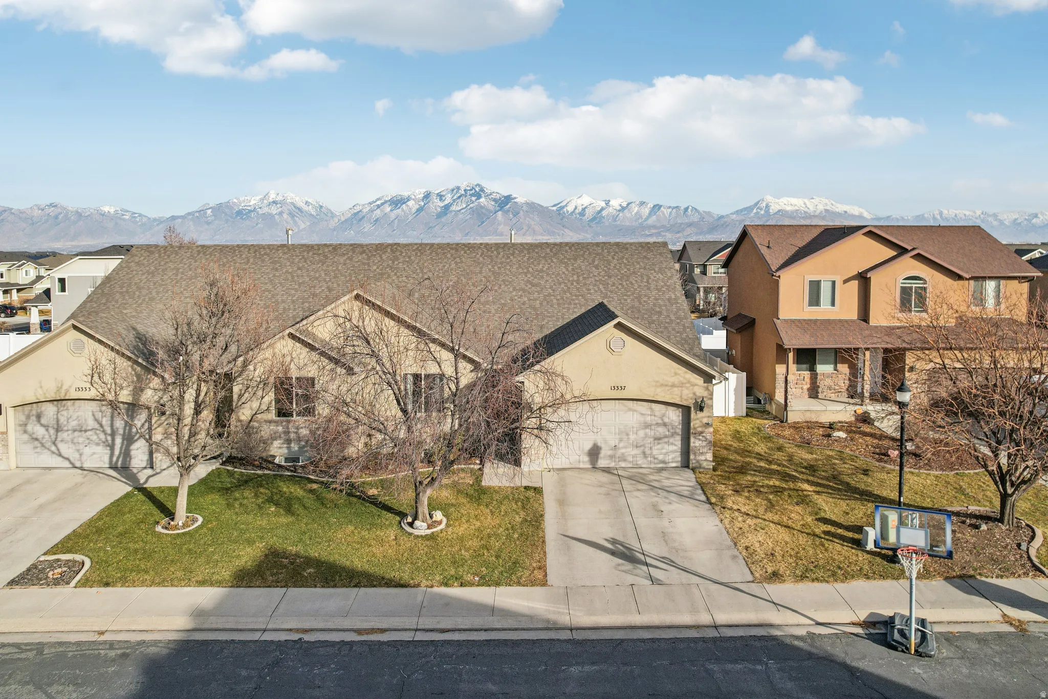 View of front of property featuring concrete driveway, an attached garage, a front lawn, a residential view, and a mountain view