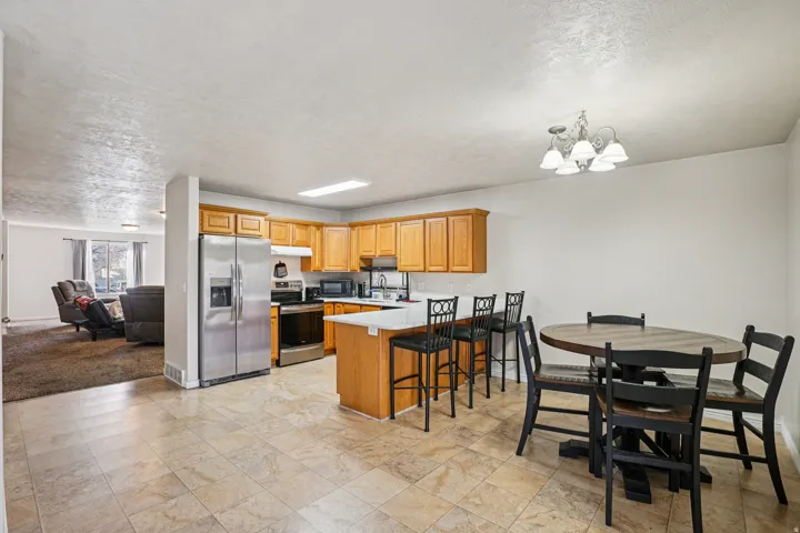 Kitchen with appliances with stainless steel finishes, light countertops, a peninsula, a breakfast bar, and a textured ceiling