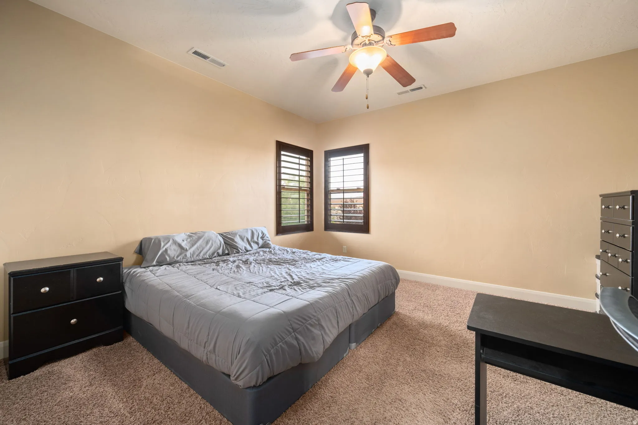 Carpeted bedroom with baseboards and a ceiling fan