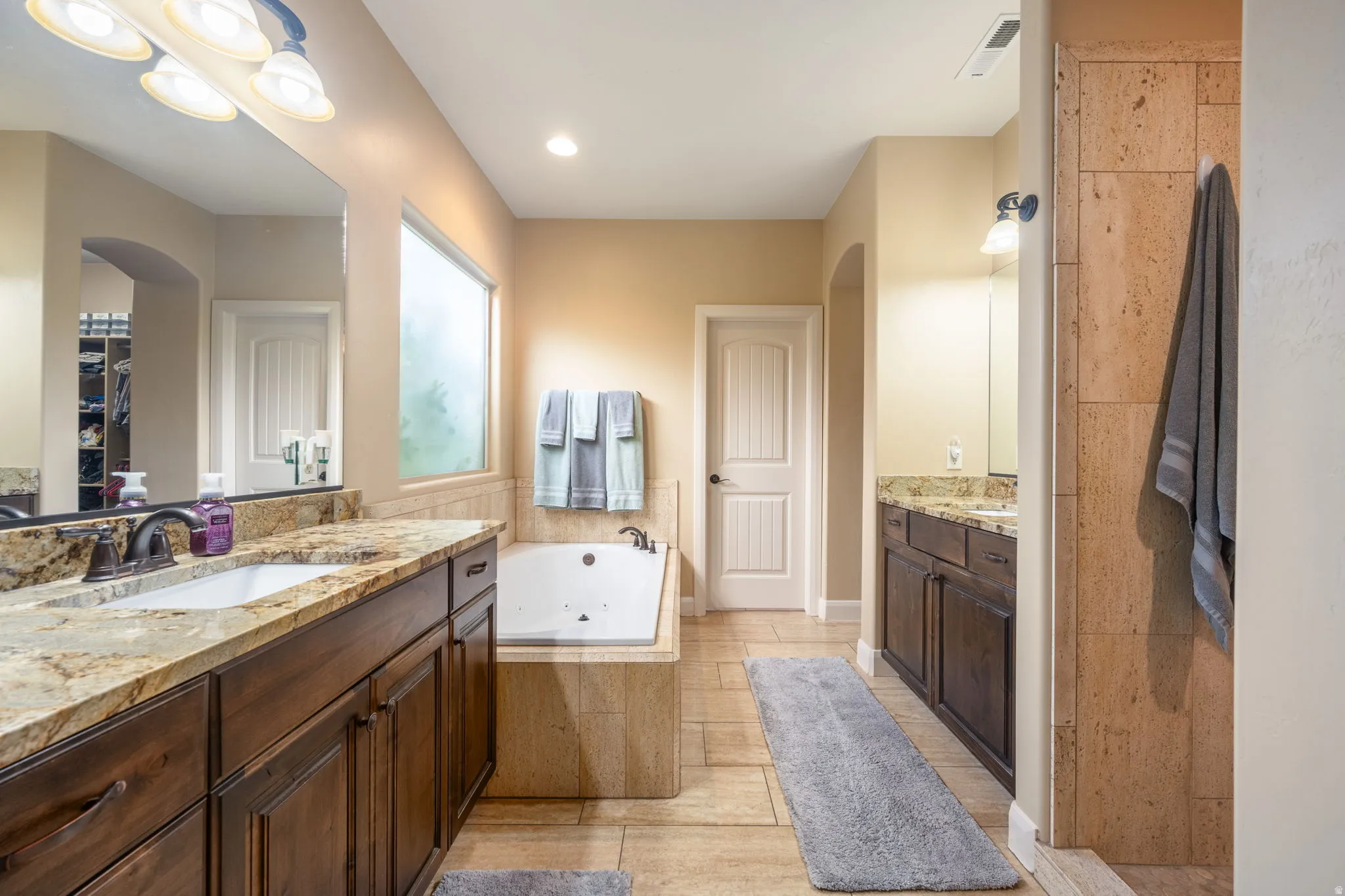 Full bathroom with two vanities and a whirlpool tub