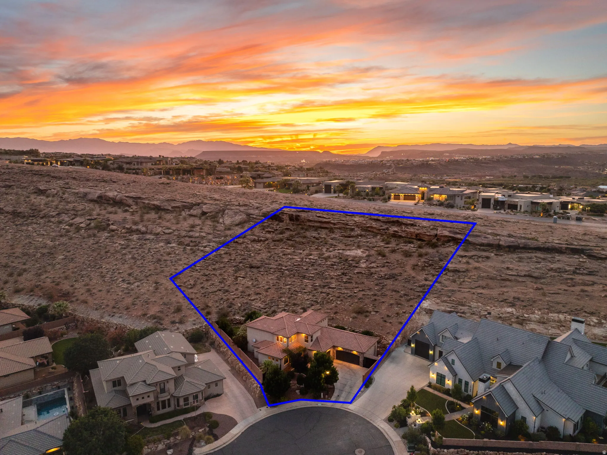 Aerial perspective of suburban area with a mountainous background and property parcel outlined
