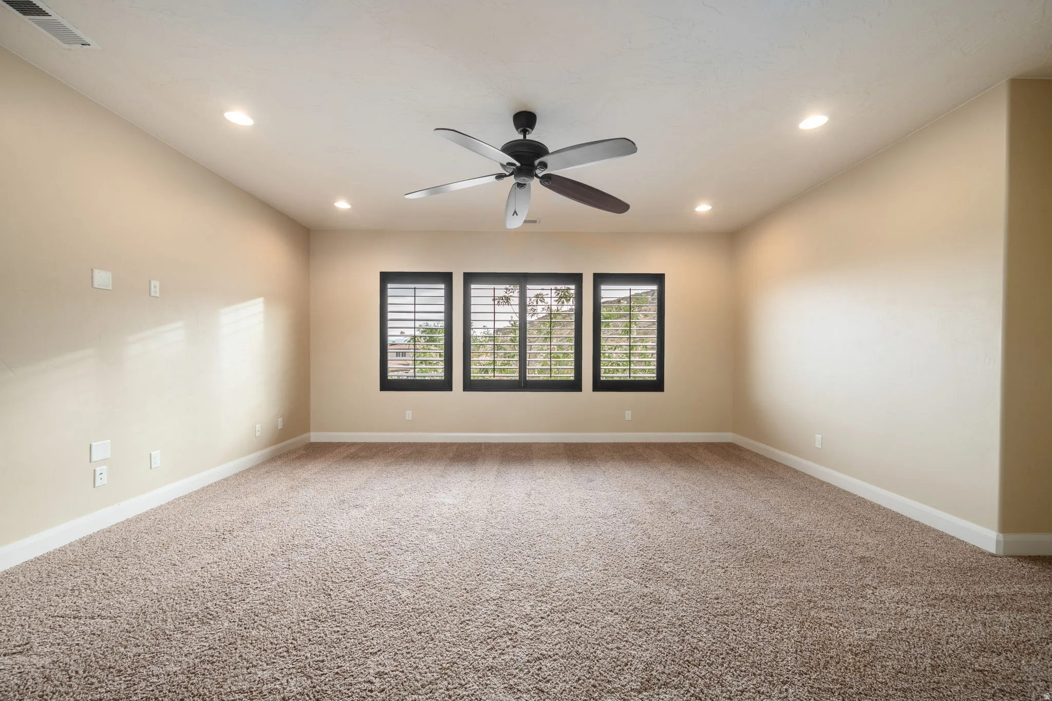 Empty room with light colored carpet, recessed lighting, and a ceiling fan