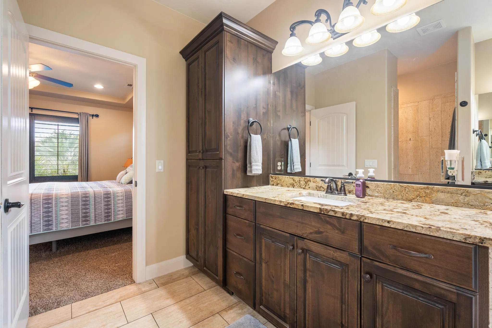 Full bath with connected bathroom, vanity, light carpet, and a raised ceiling
