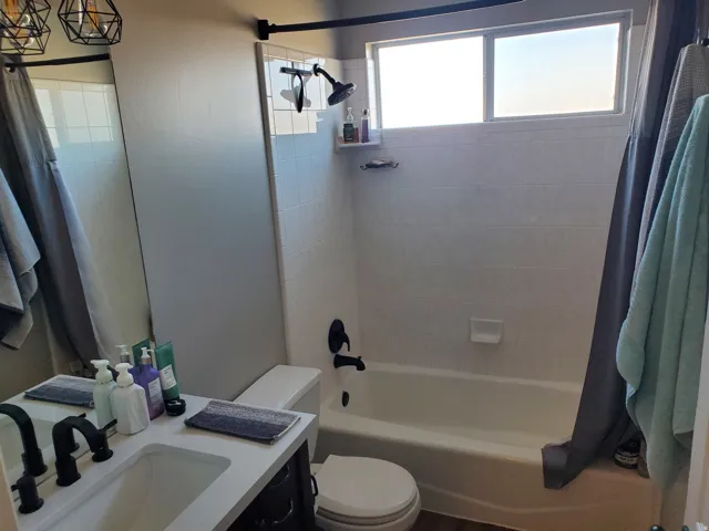 Bathroom featuring shower / bathtub combination with curtain and vanity