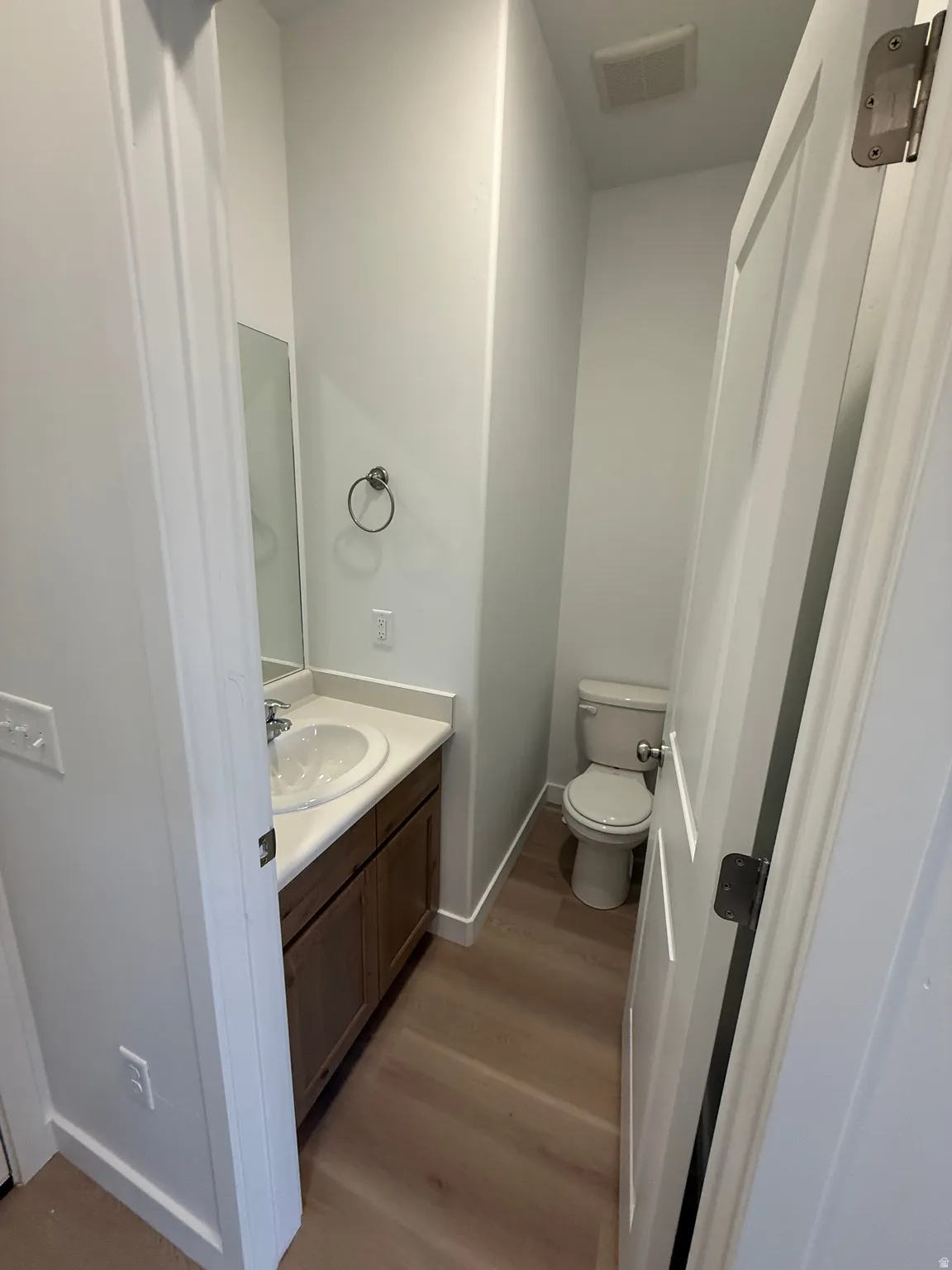 Half bath with vanity and dark wood finished floors