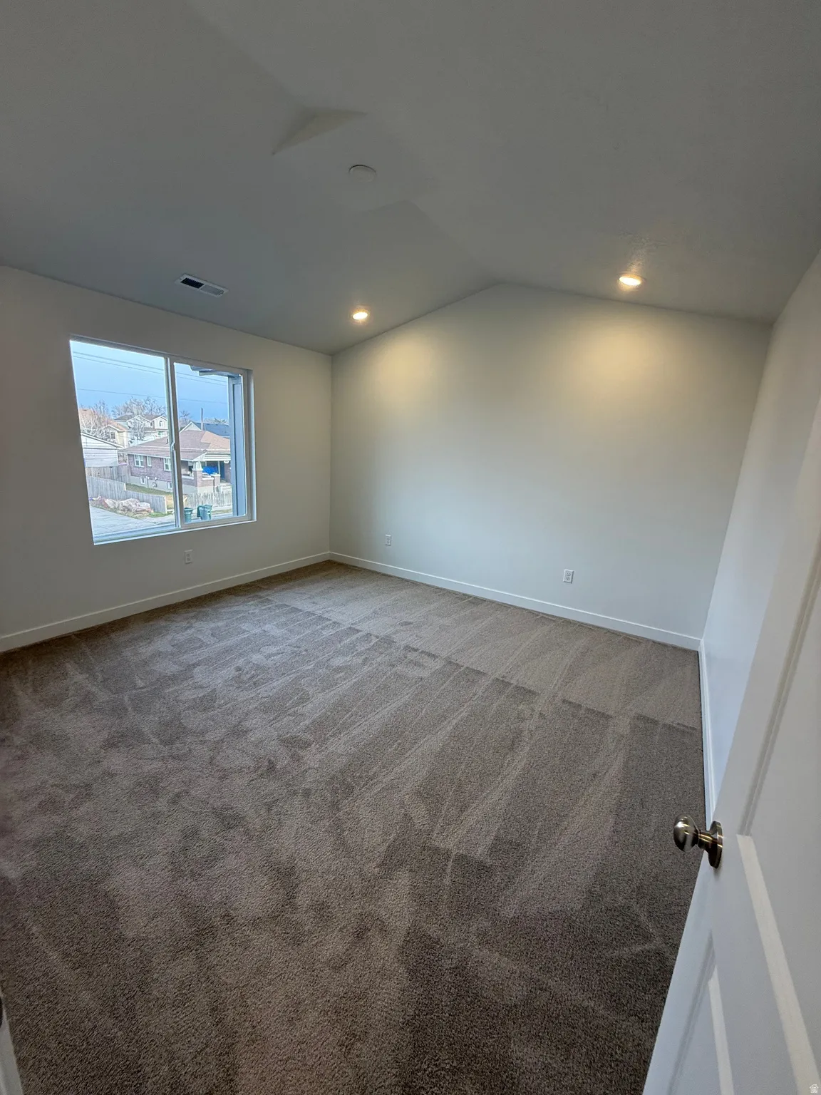 Unfurnished room with carpet floors, lofted ceiling, and recessed lighting