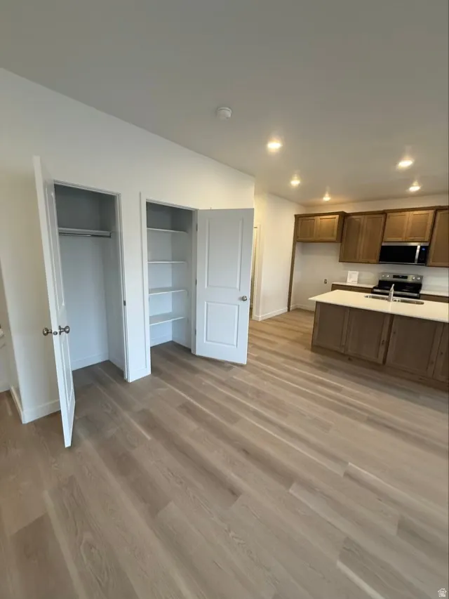 Kitchen with light countertops, stainless steel appliances, light wood-style floors, and recessed lighting
