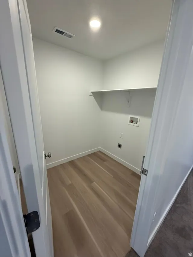 Washroom with dark wood-style floors, washer hookup, and electric dryer hookup