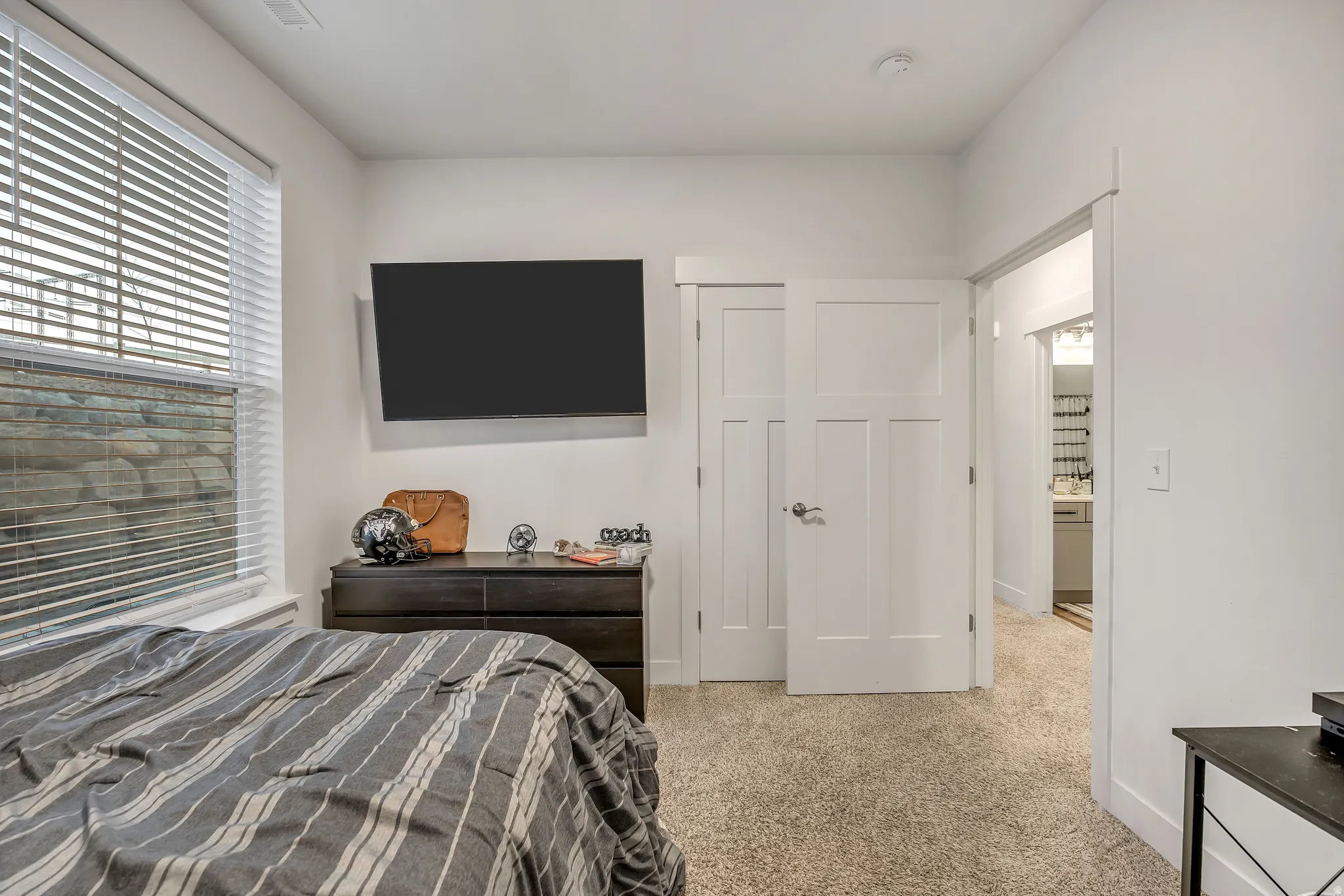Bedroom featuring light carpet and baseboards