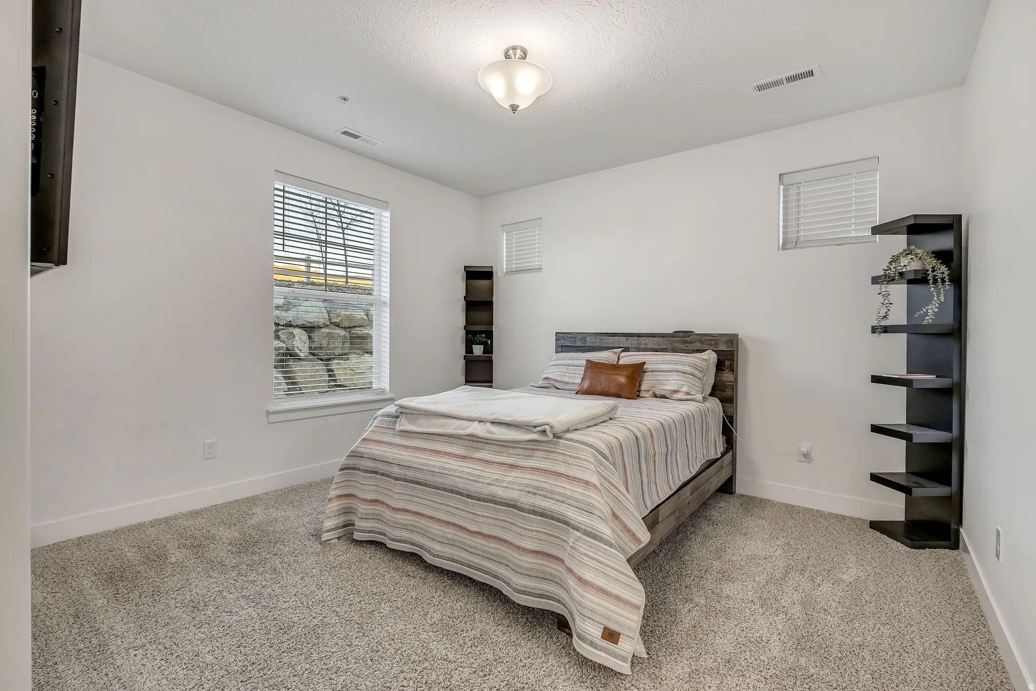 Bedroom with light colored carpet and baseboards