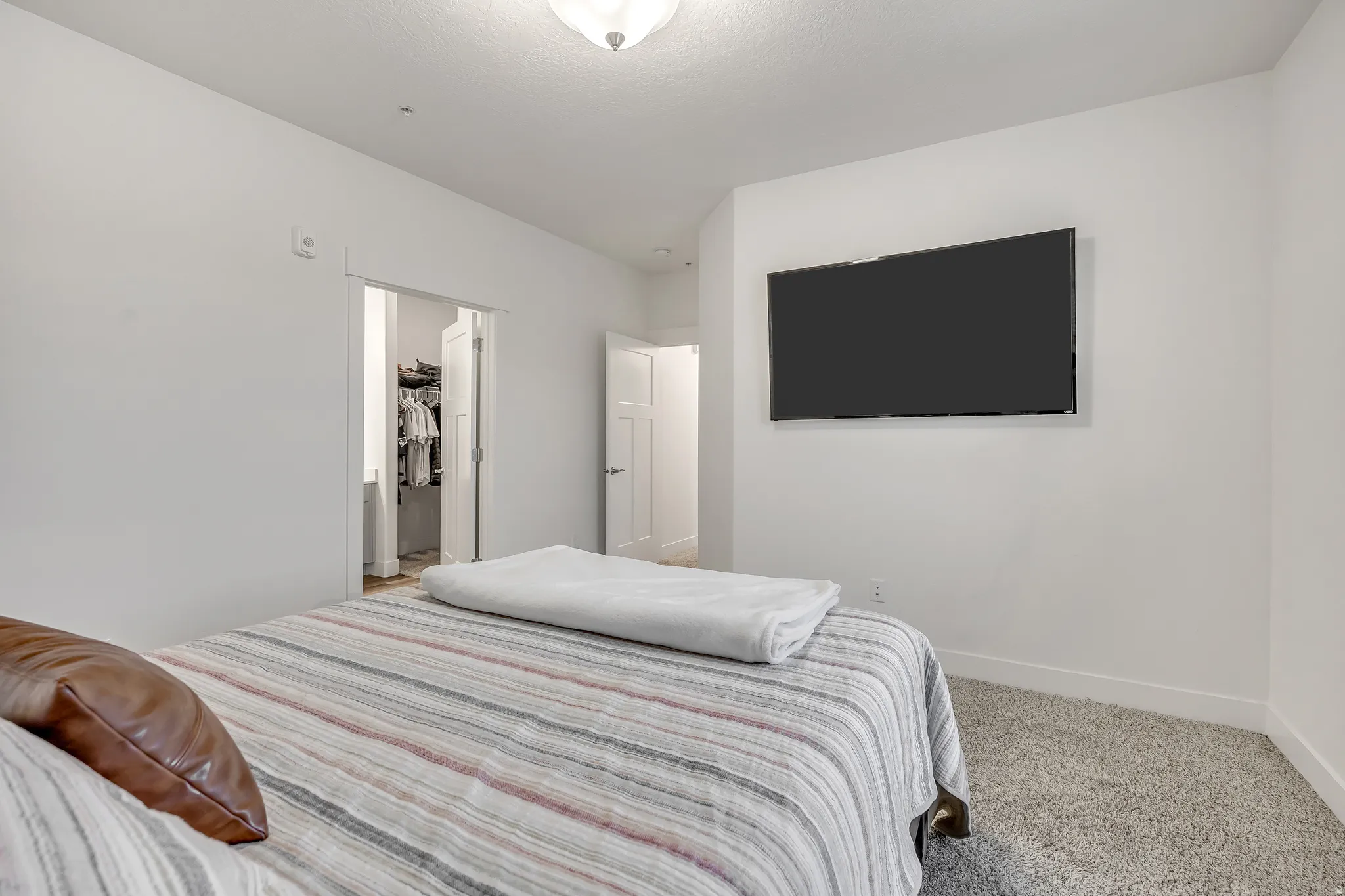 Carpeted bedroom with baseboards and a walk in closet