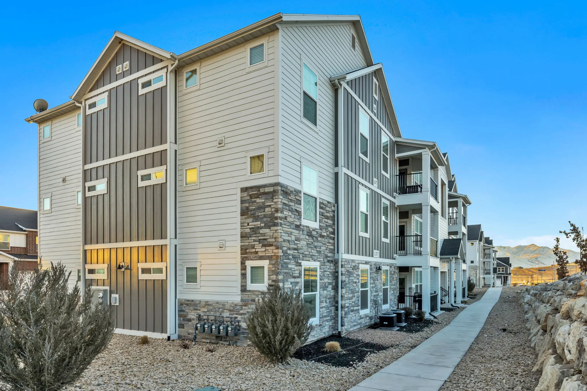 View of home's exterior with board and batten siding, stone siding, and a mountain view