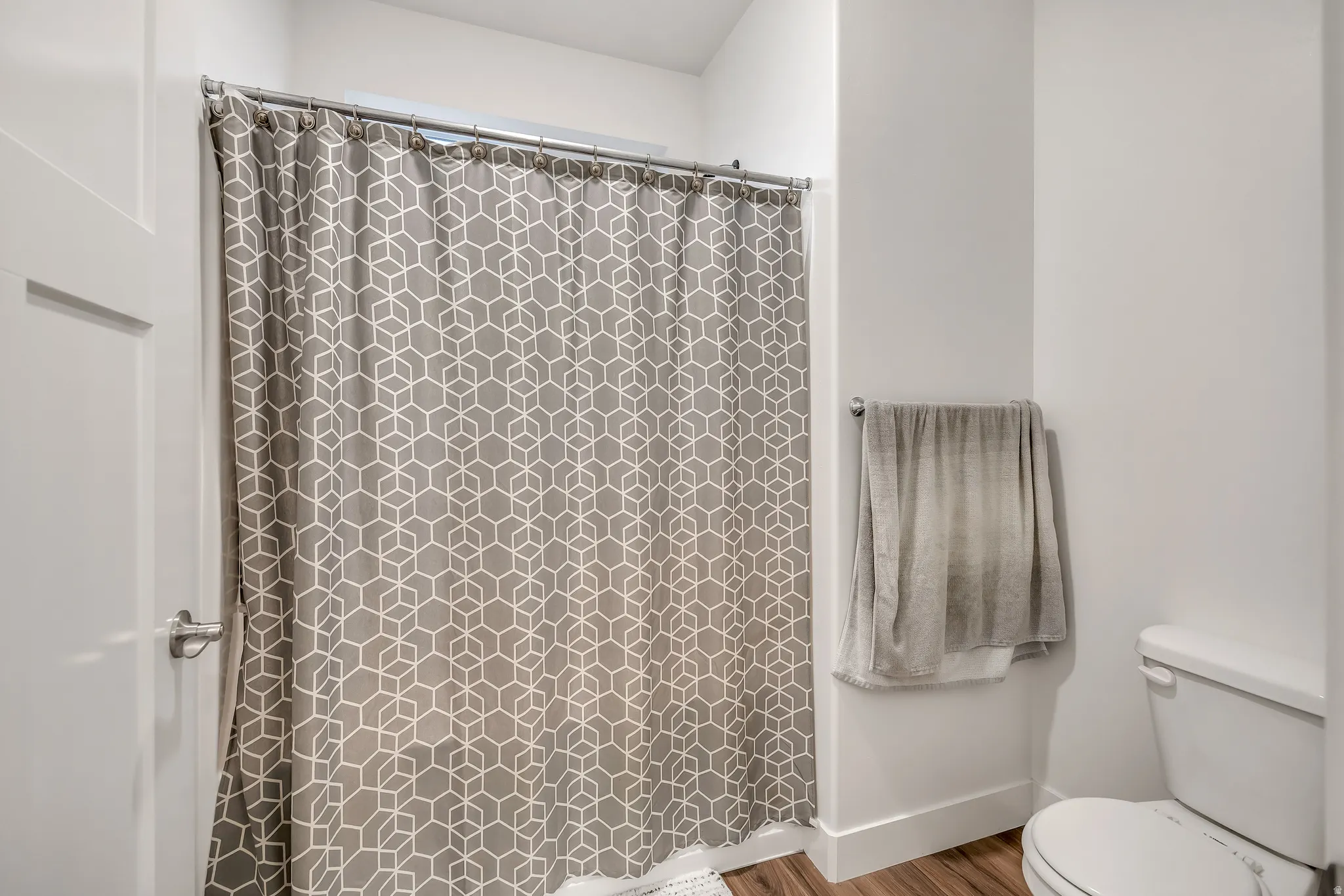 Bathroom featuring a shower with shower curtain and wood finished floors