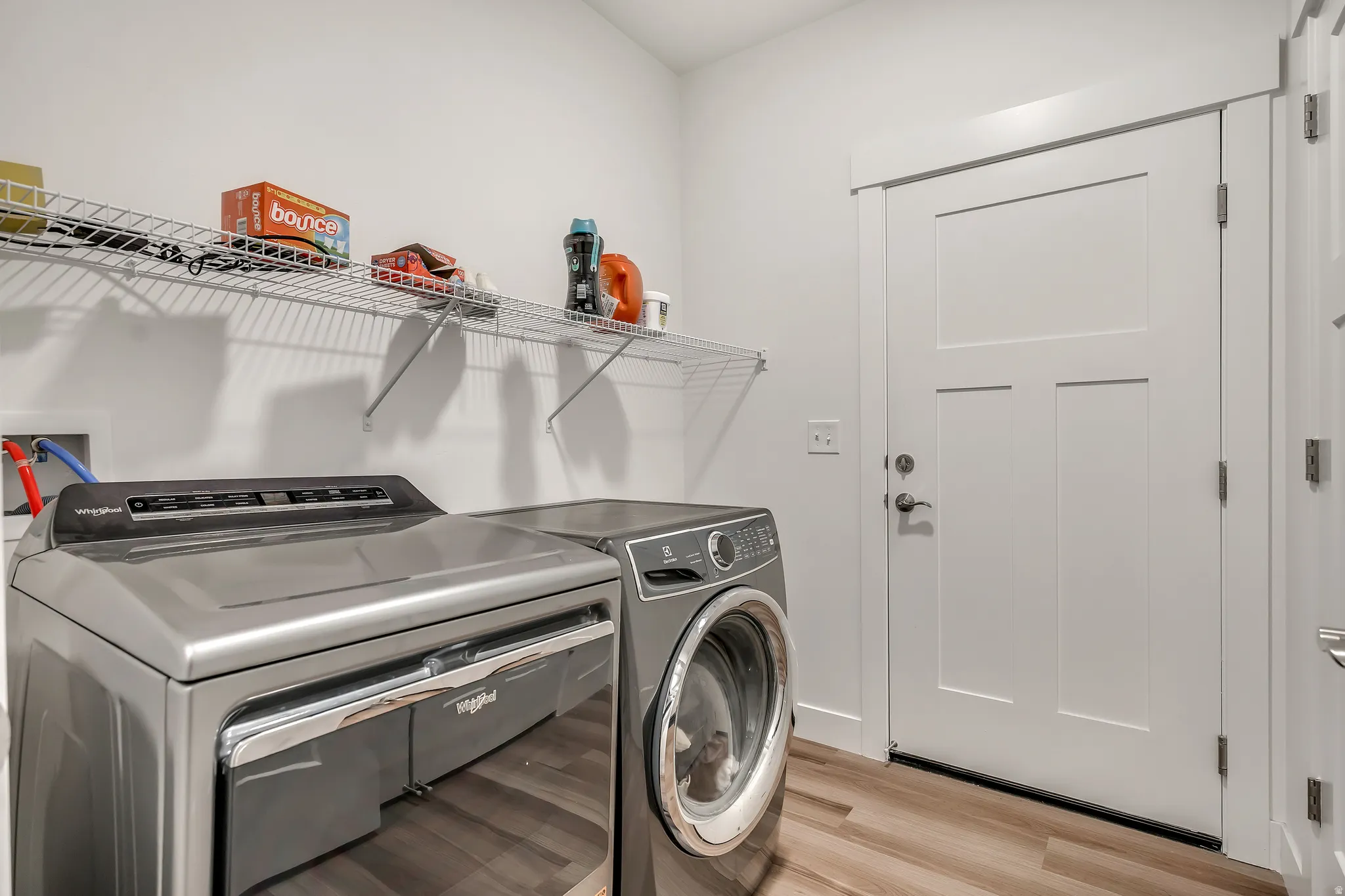 Washroom with light wood finished floors and separate washer and dryer