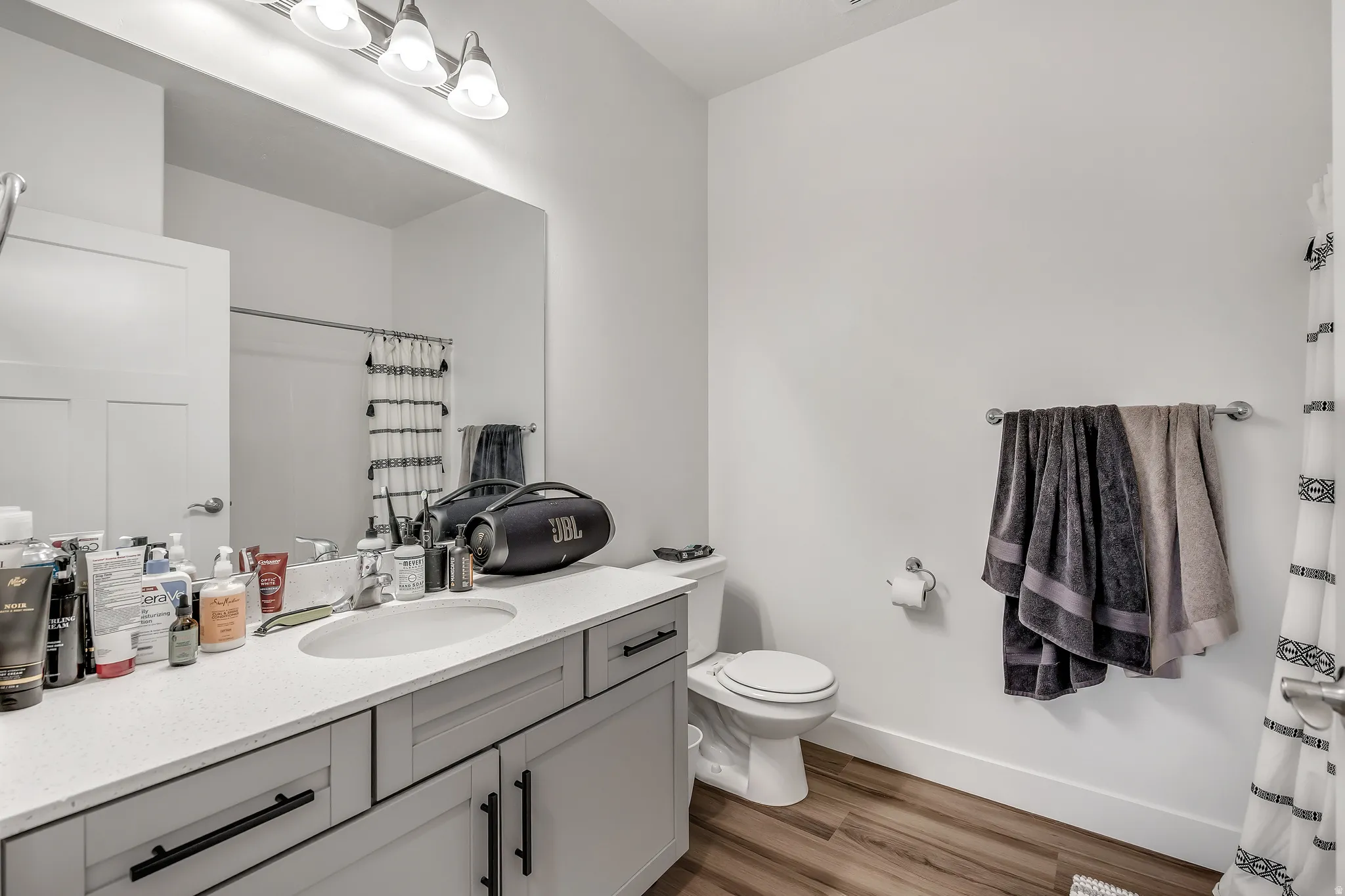 Bathroom with a shower with curtain, vanity, and light wood finished floors
