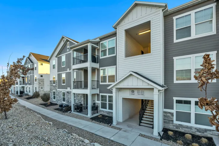 View of front of property featuring stone siding, board and batten siding, stairs, and a residential view