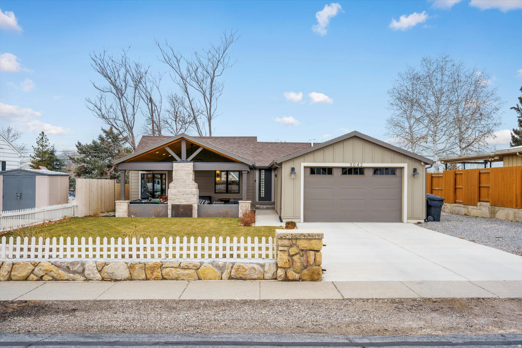 View of front facade with concrete driveway, covered porch, board and batten siding, and a garage