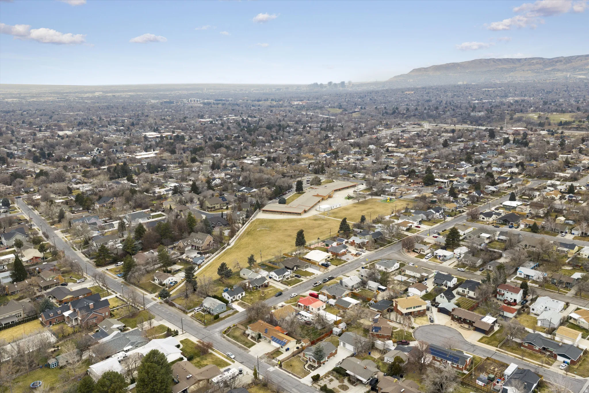 Aerial view of property's location with nearby suburban area and a mountainous background