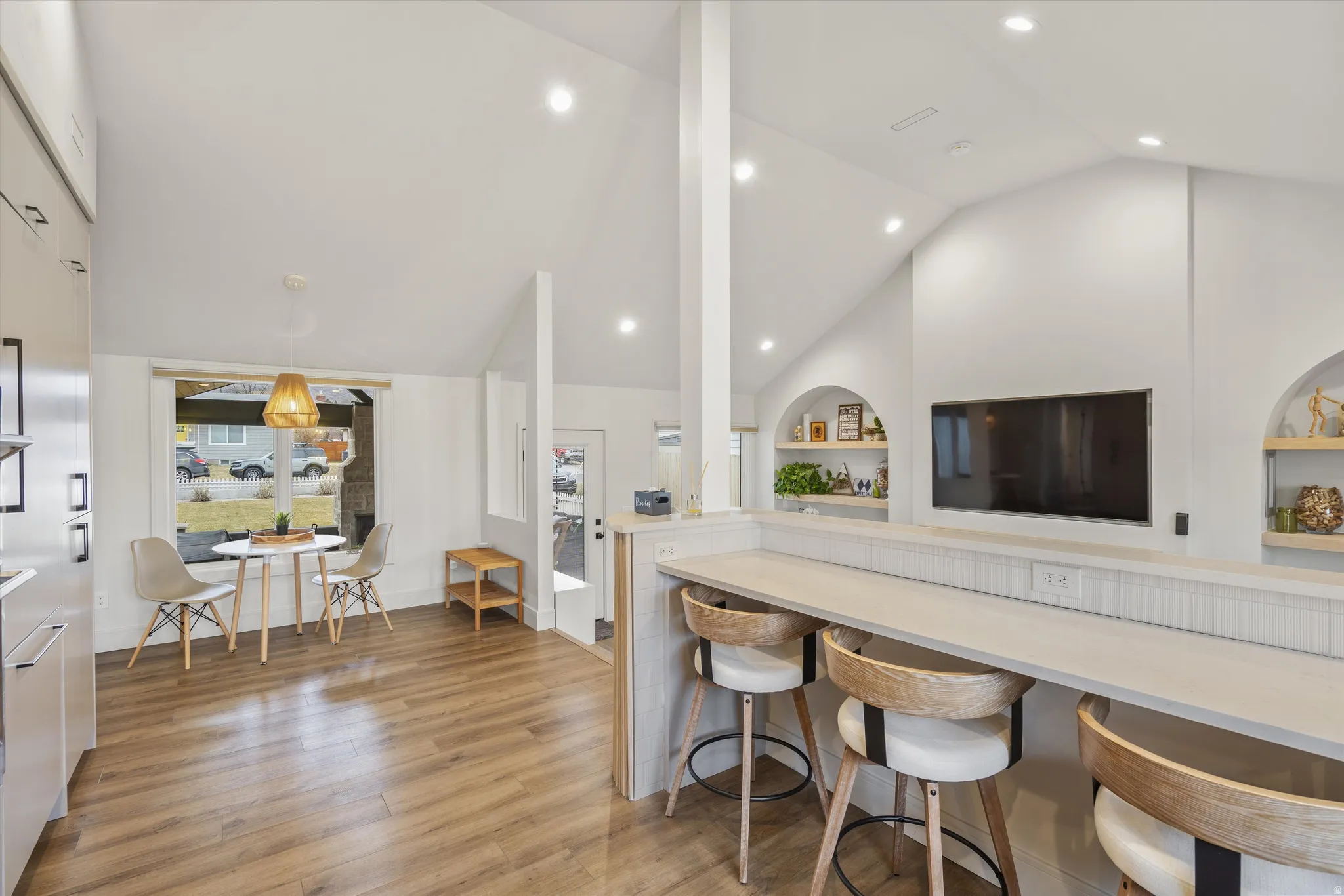 Kitchen featuring light wood-style floors, high vaulted ceiling, built in features, pendant lighting, and recessed lighting