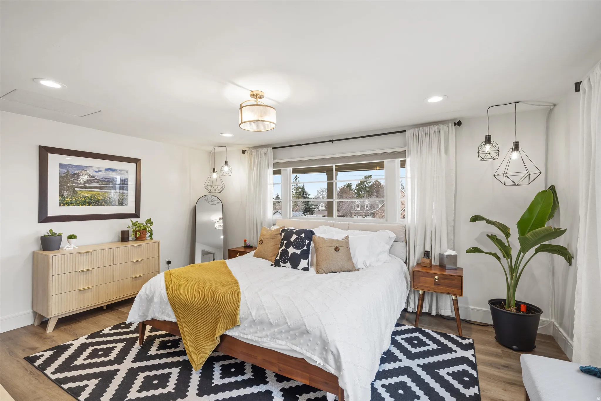Primary Bedroom with wood finished floors and recessed lighting