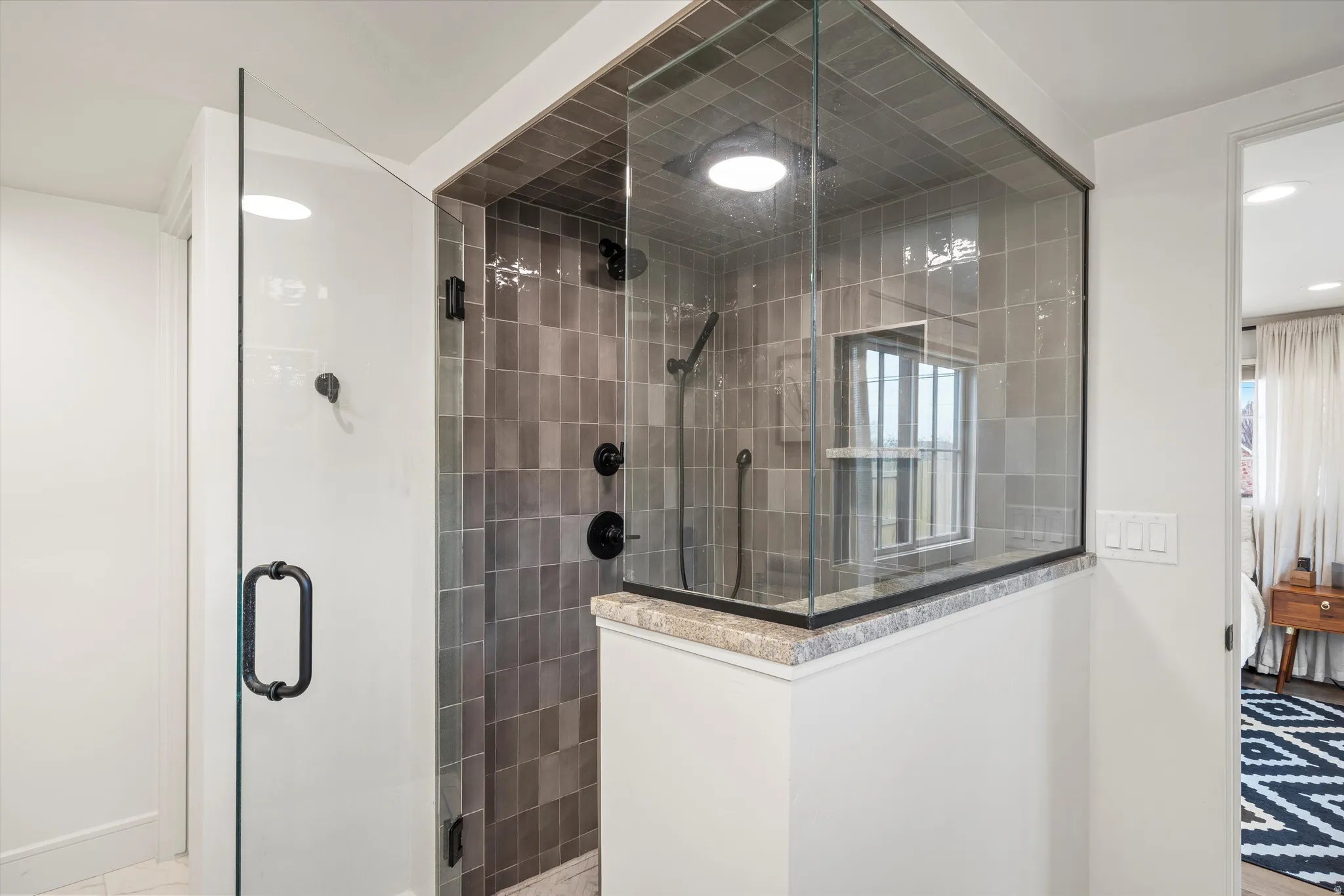 Ensuite bathroom with tiled shower, healthy amount of natural light, and recessed lighting