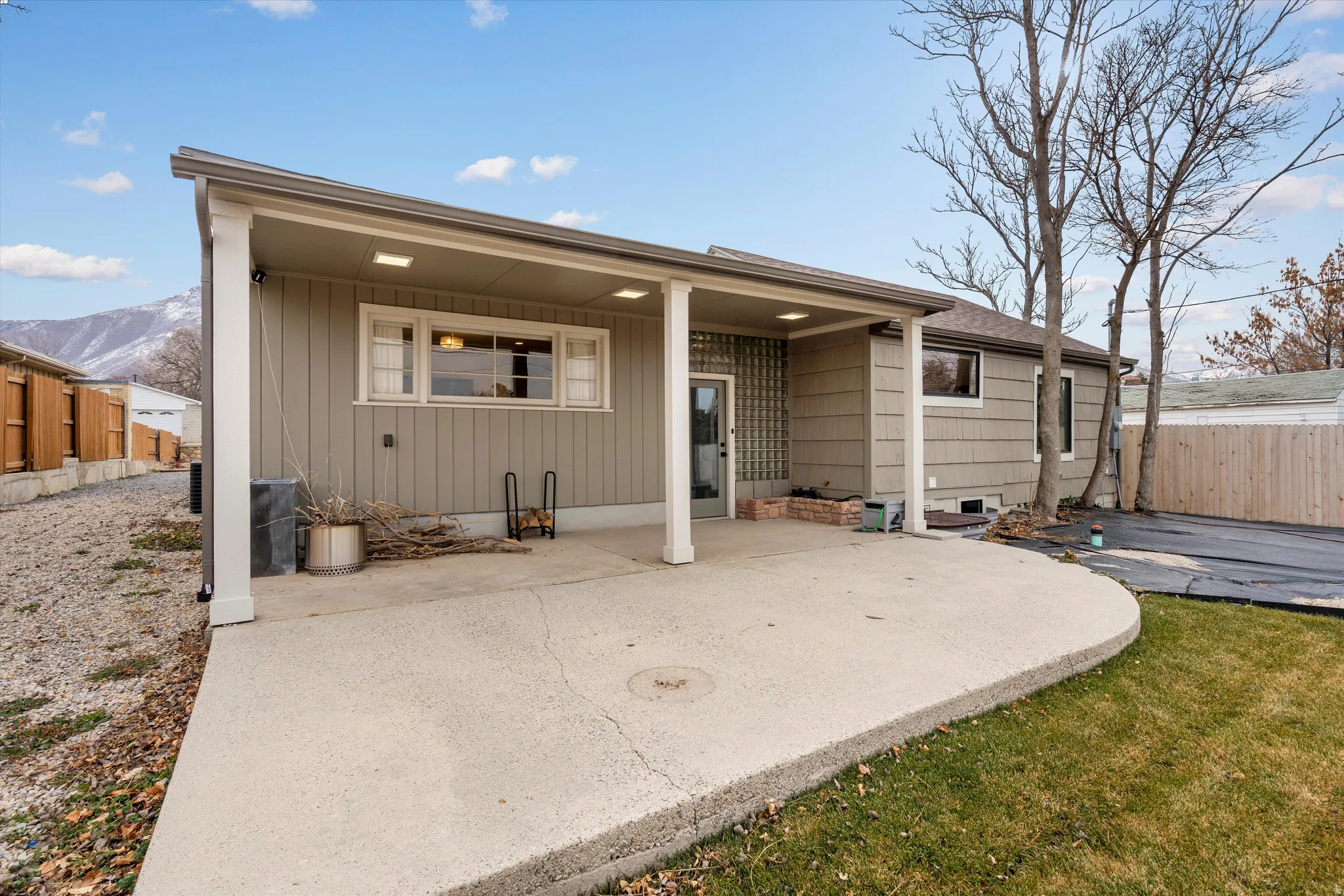 Back of property with a patio, a mountain view, and roof with shingles