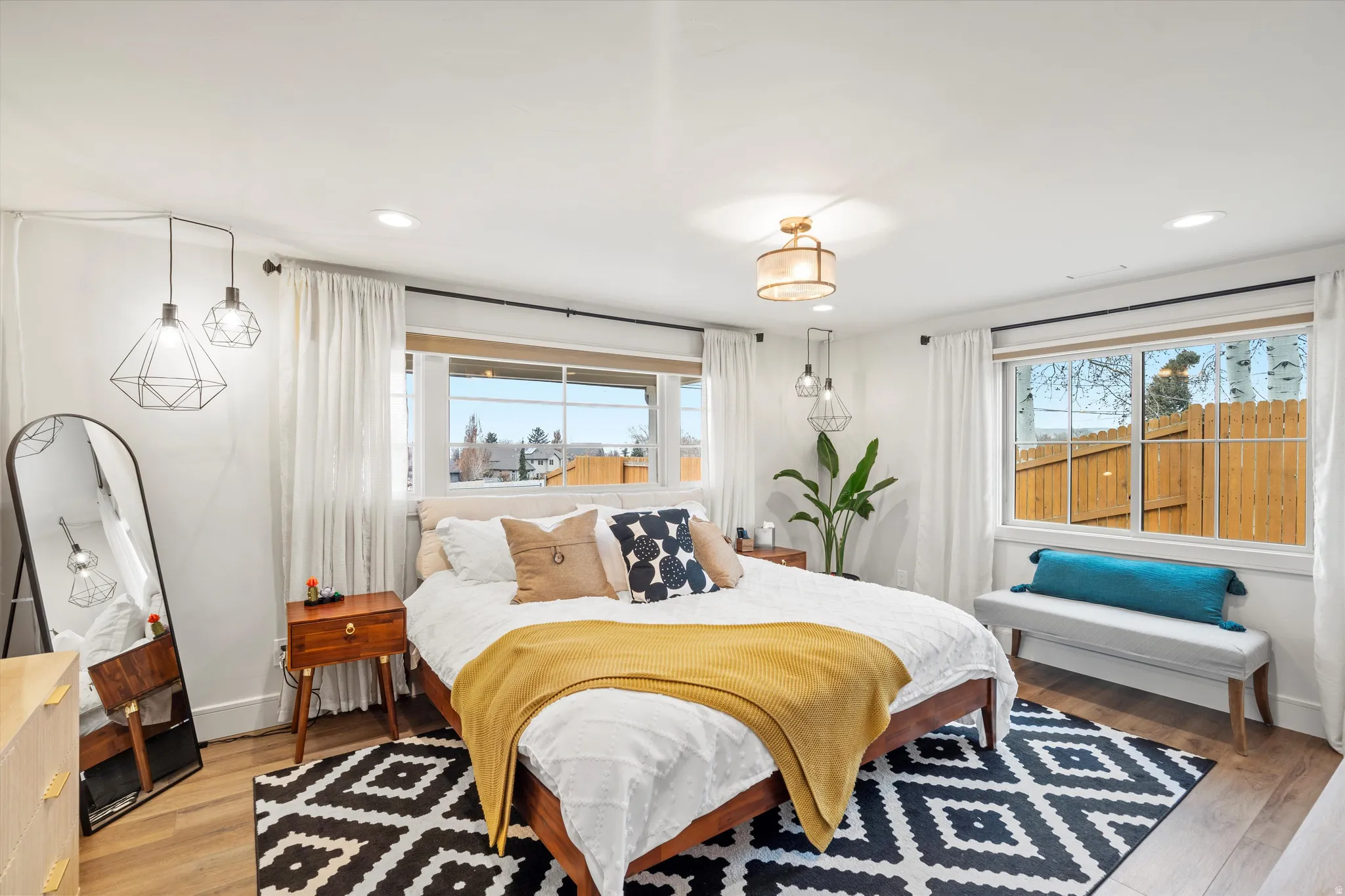 Primary bedroom with light wood-style floors and recessed lighting