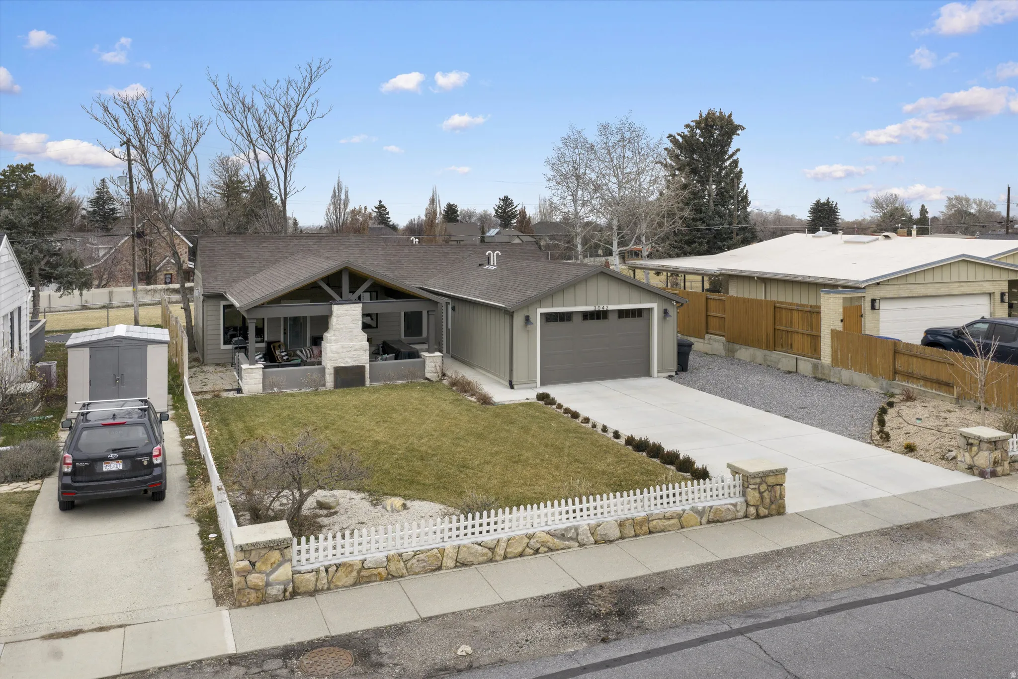 View of front of home with driveway, a porch, a garage, and a shingled roof