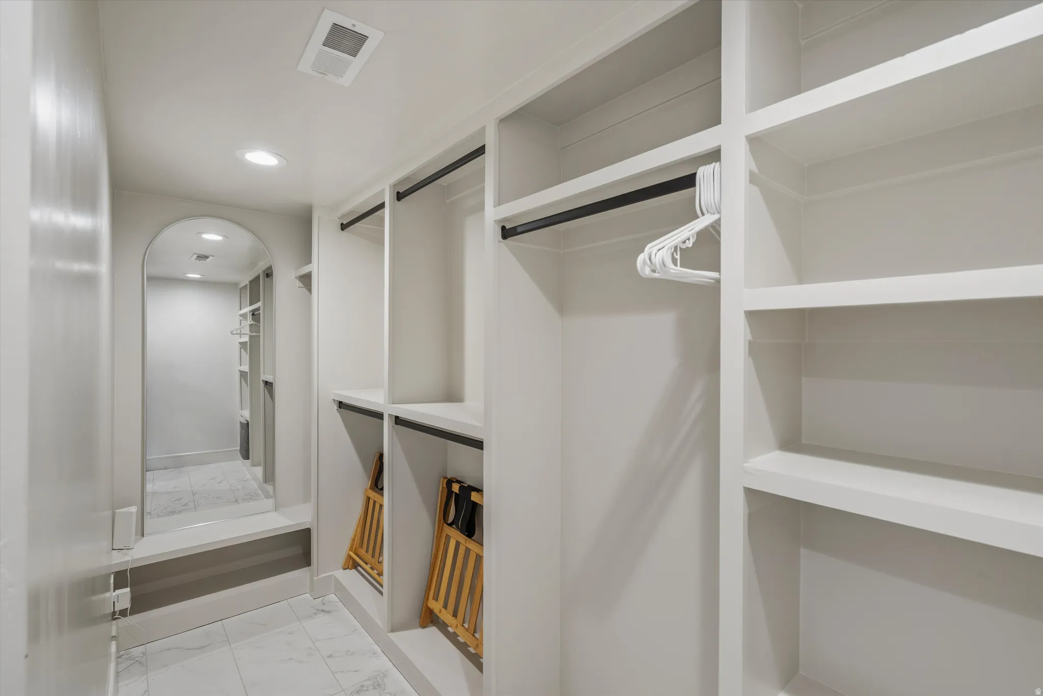 Spacious closet with light marble finish floors