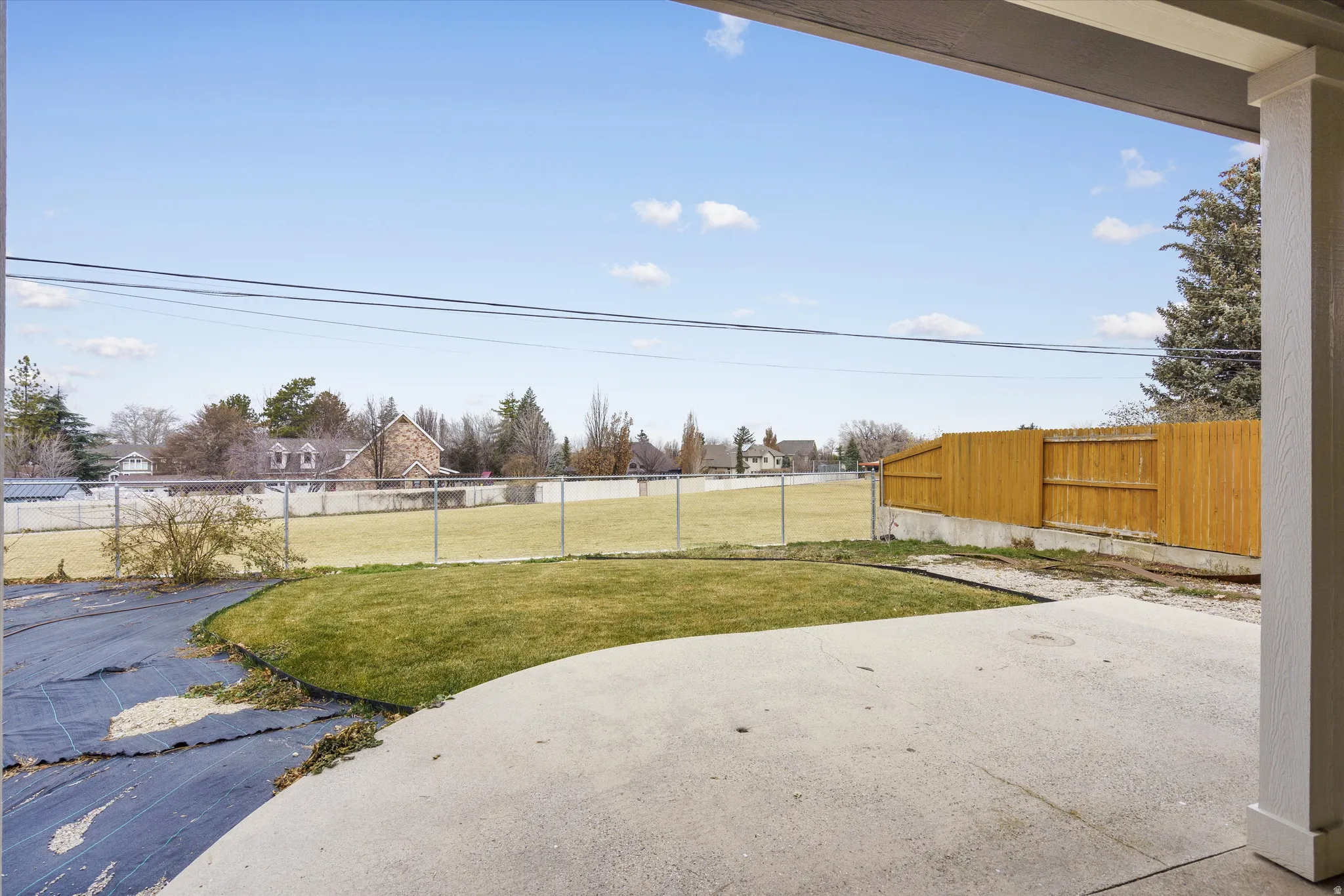 Fenced backyard featuring a patio and a residential view