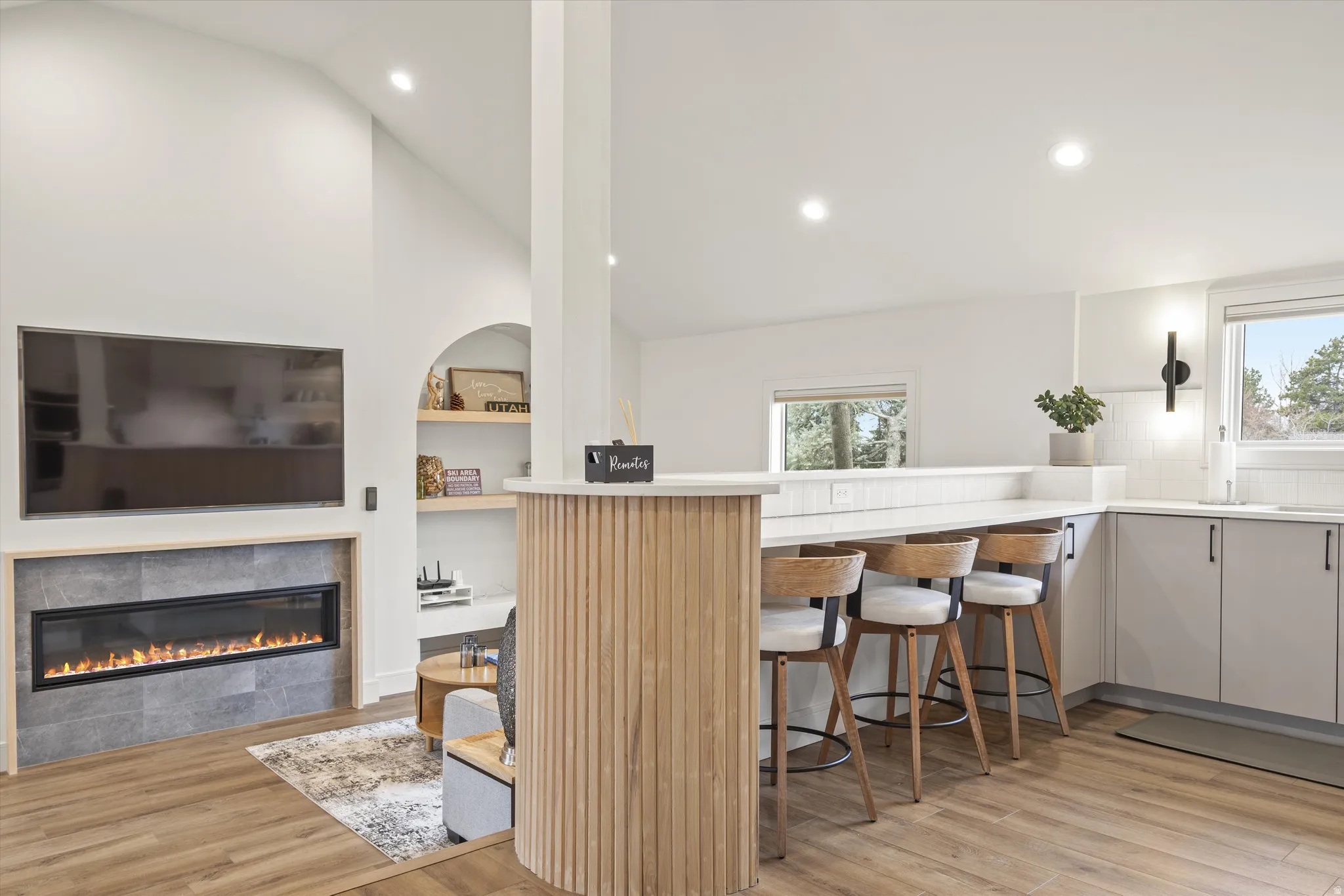 Kitchen featuring light countertops, plenty of natural light, light wood-style flooring, recessed lighting, and high vaulted ceiling