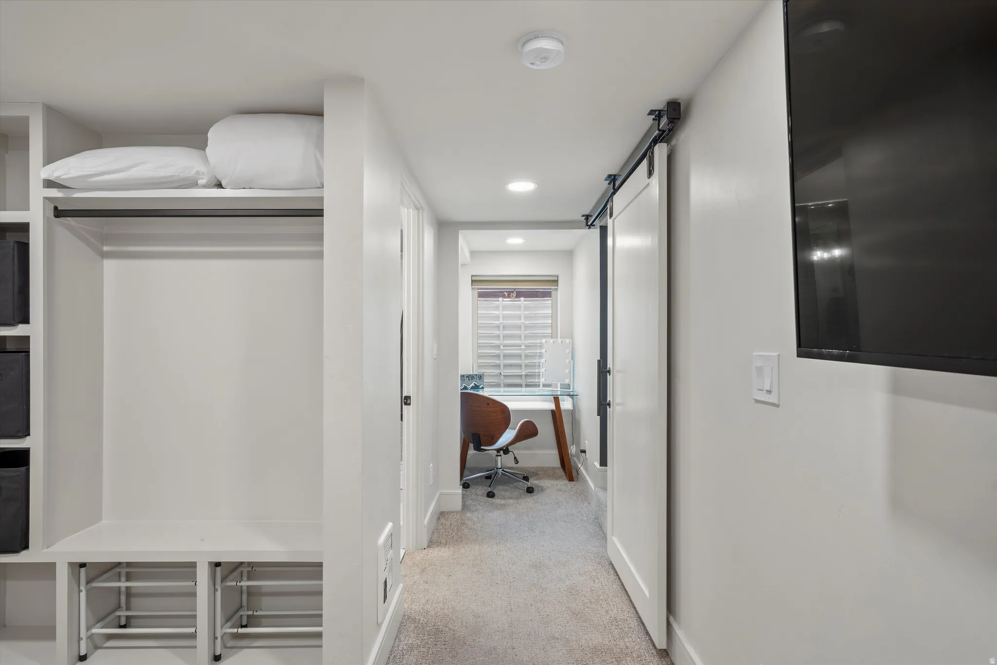 Corridor with light carpet, recessed lighting, a barn door, and an office area