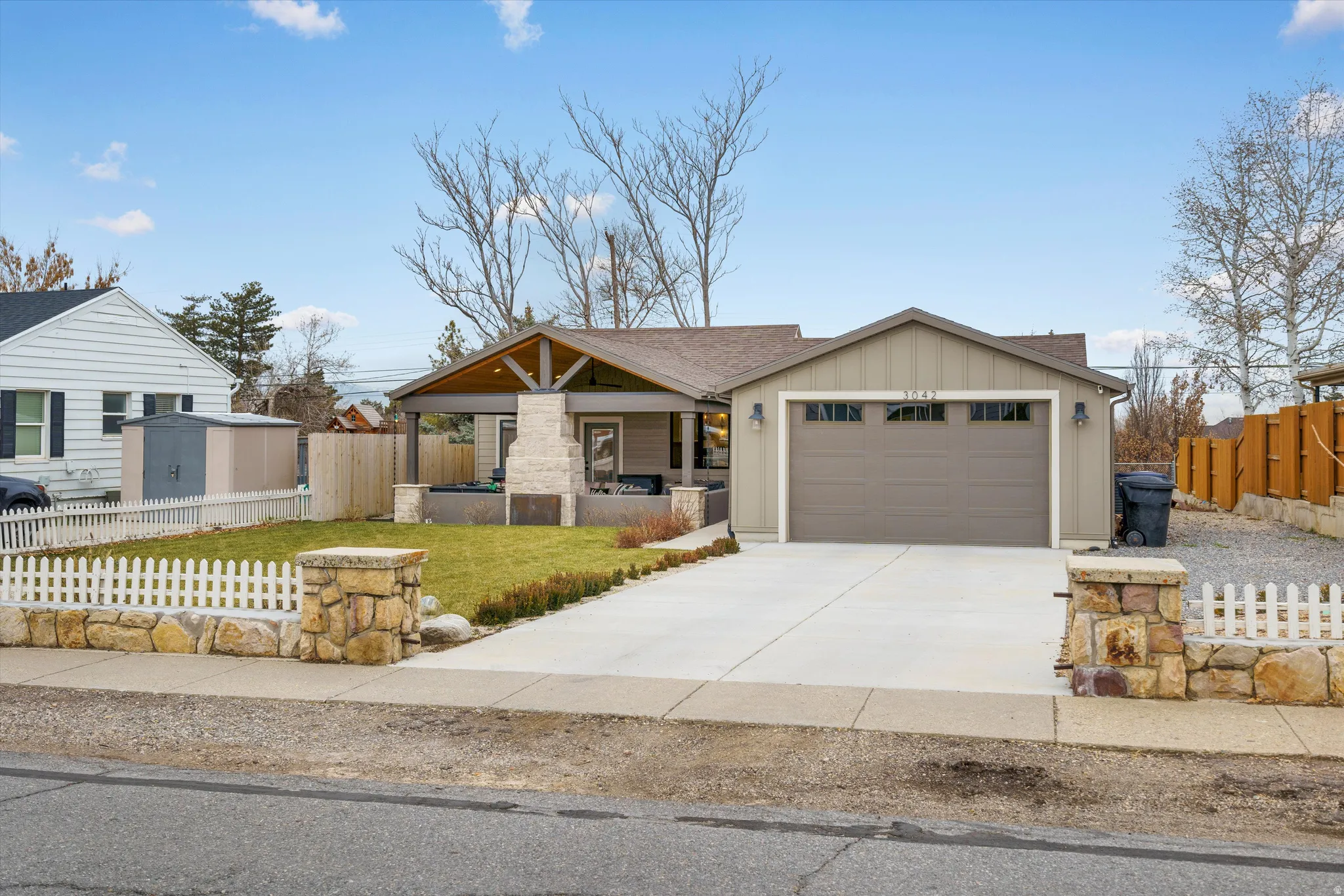 View of front of house featuring board and batten siding, concrete driveway, a porch, an attached garage, and roof with shingles