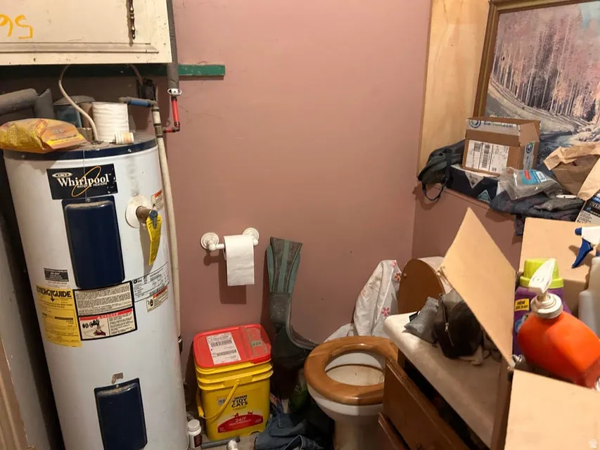 Bathroom featuring electric water heater and toilet