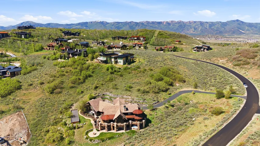 Custom multi-level residence with stone and wood siding, a grand turret, and multiple balconies