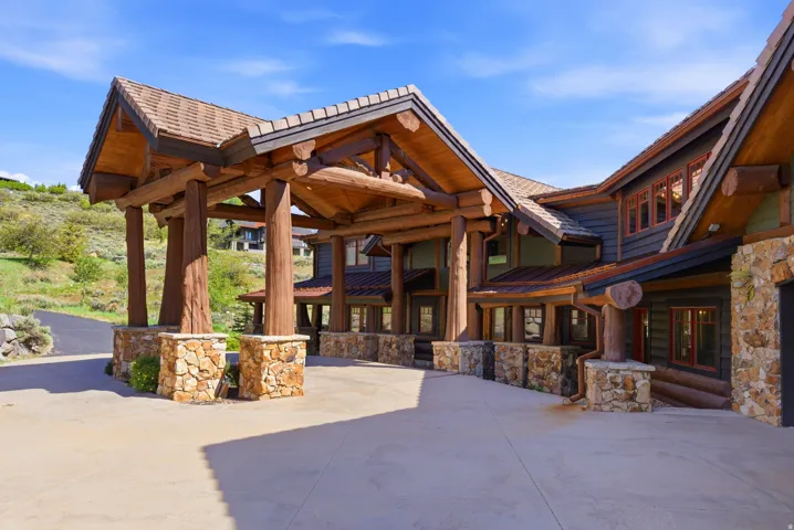 Covered entry with exposed log beam construction and stone bases