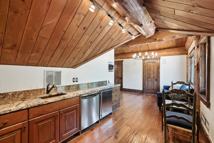 Rustic-inspired interior with wood-finish flooring, exposed wooden beams, and a planked wood ceiling