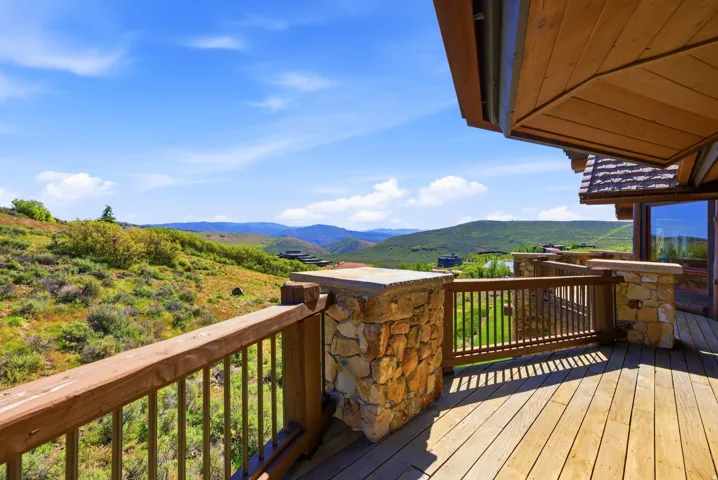 Wood-plank outdoor deck with stone pillars and wood railings