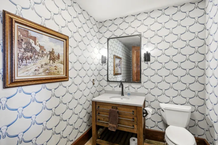 Bathroom featuring a wooden vanity with a white countertop, an undermount sink, and a matte black faucet